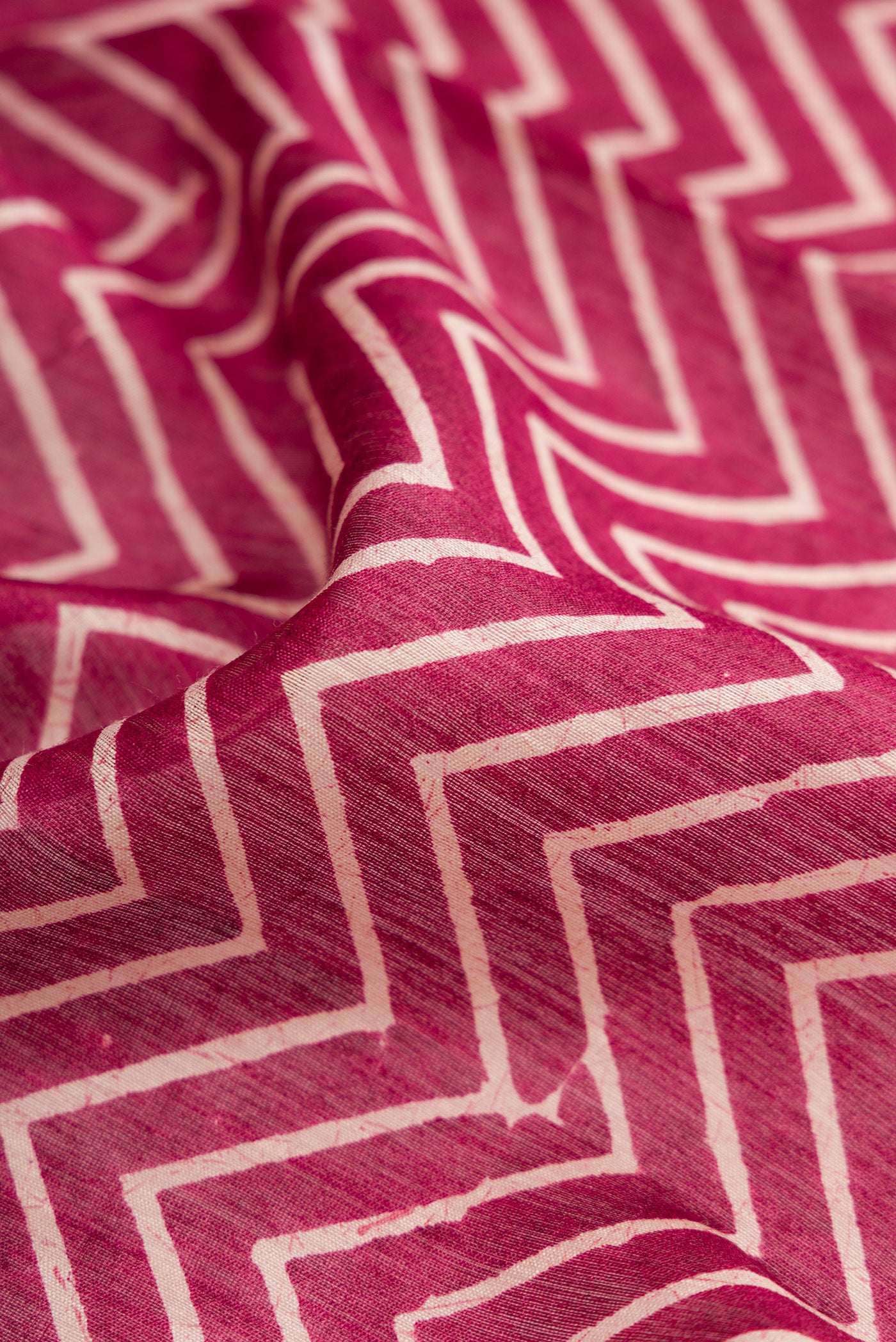 Close up of Burgundy Dual Tone Tussar Silk Saree with Printed design on the body and Zari Border.  displaying folds