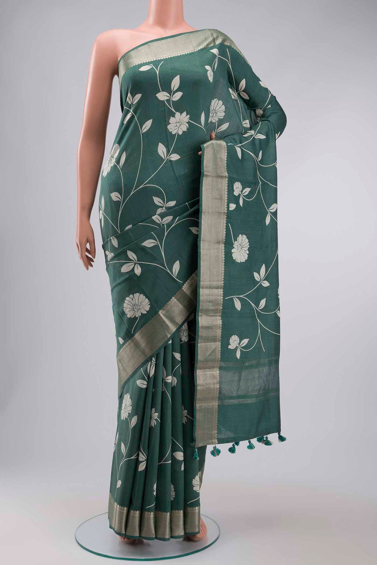 Green Tussar Silk Saree with Printed design on the body and Zari Border displayed on a mannequin