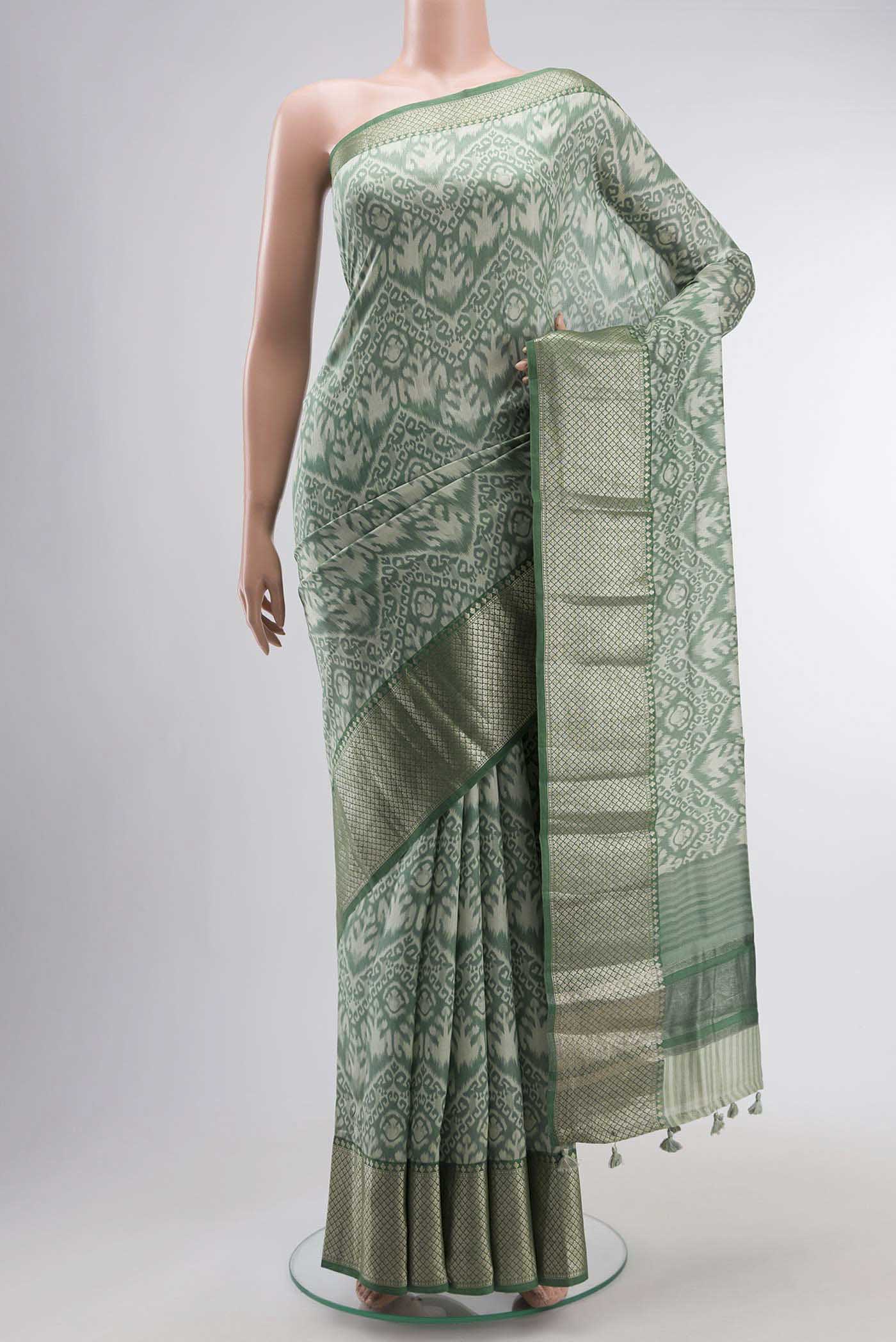 Green Tussar Silk Saree with Printed design on the body and Zari Border displayed on a mannequin