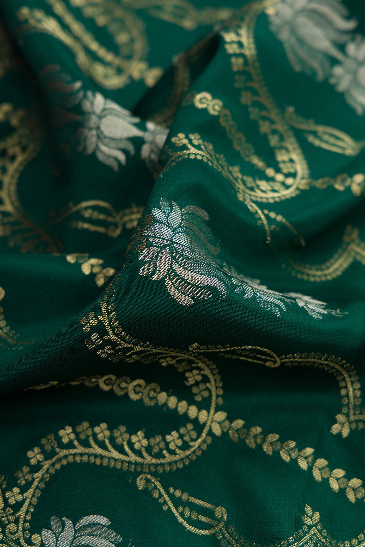 Close up of Bottle Green Dual Tone Banarasi Georgette Saree with Zari Brocade on the body and Zari Border.  displaying folds