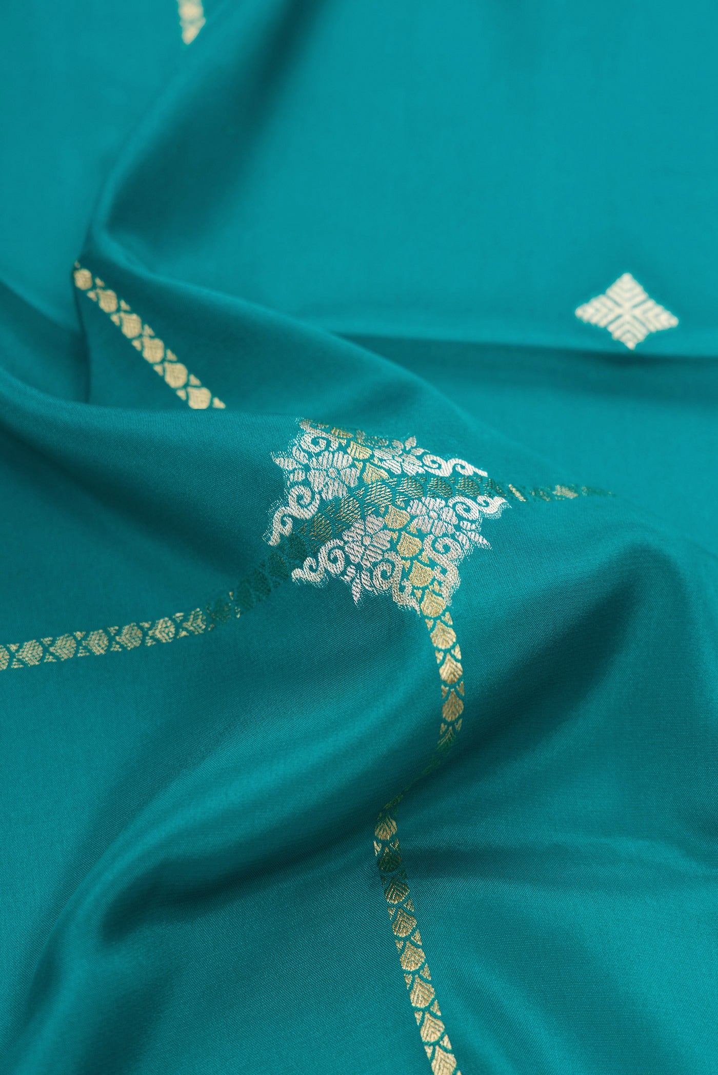 Close up of Peacock Blue Dual Tone Mysore Crepe Saree with Stripes on the body and Zari Border.  displaying folds