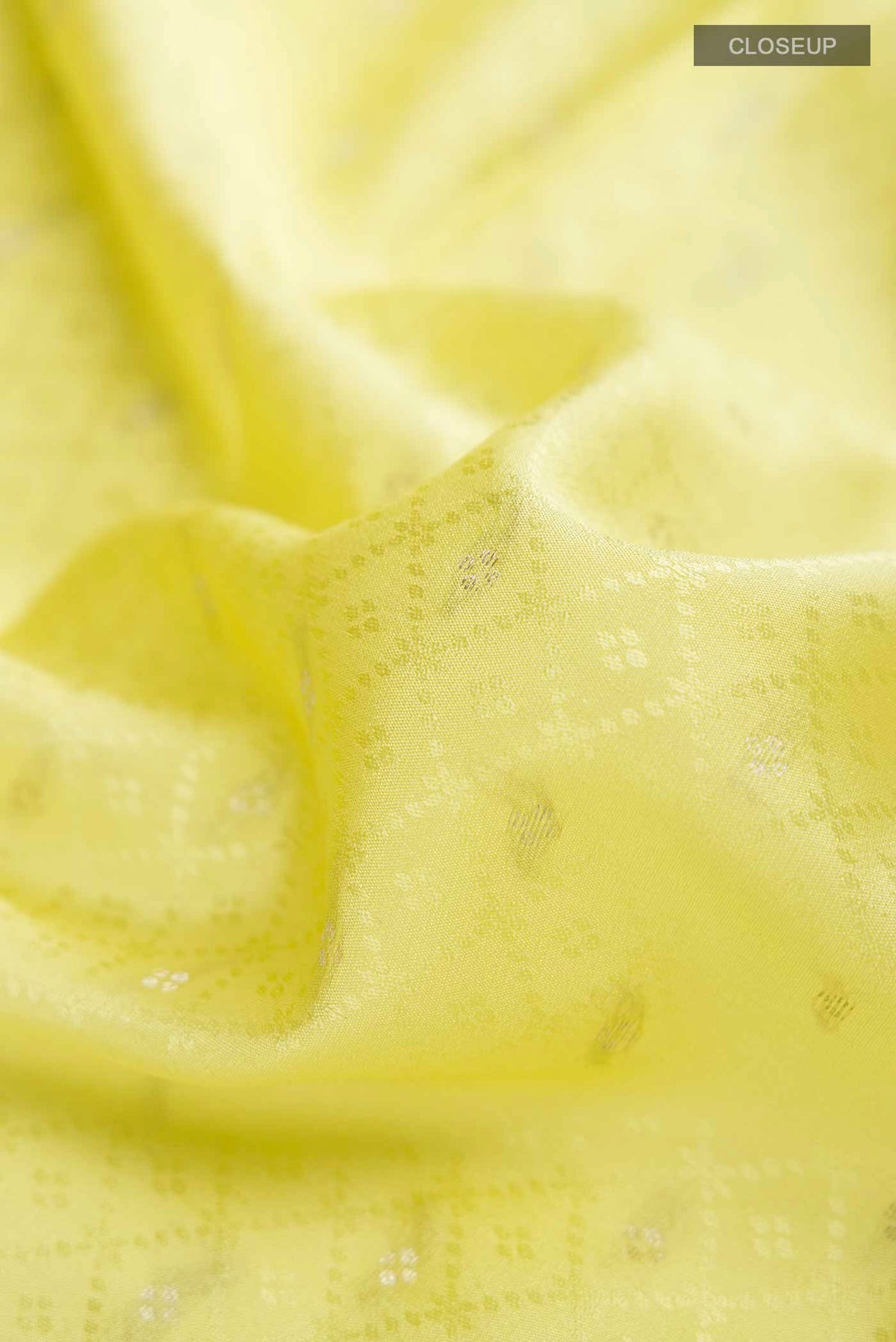 Close up of Yellow Mysore Crepe Saree with Zari Butta on the body and Zari Border displaying folds