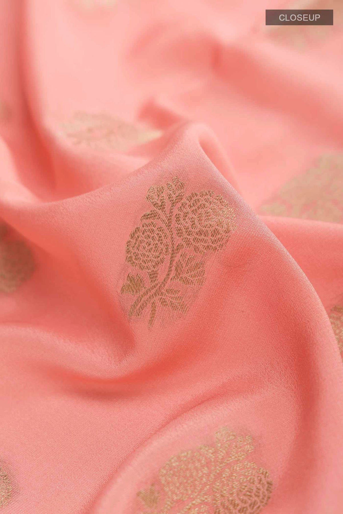 Close up of Peach Mysore Crepe Saree with Zari Butta on the body and Zari Border displaying folds