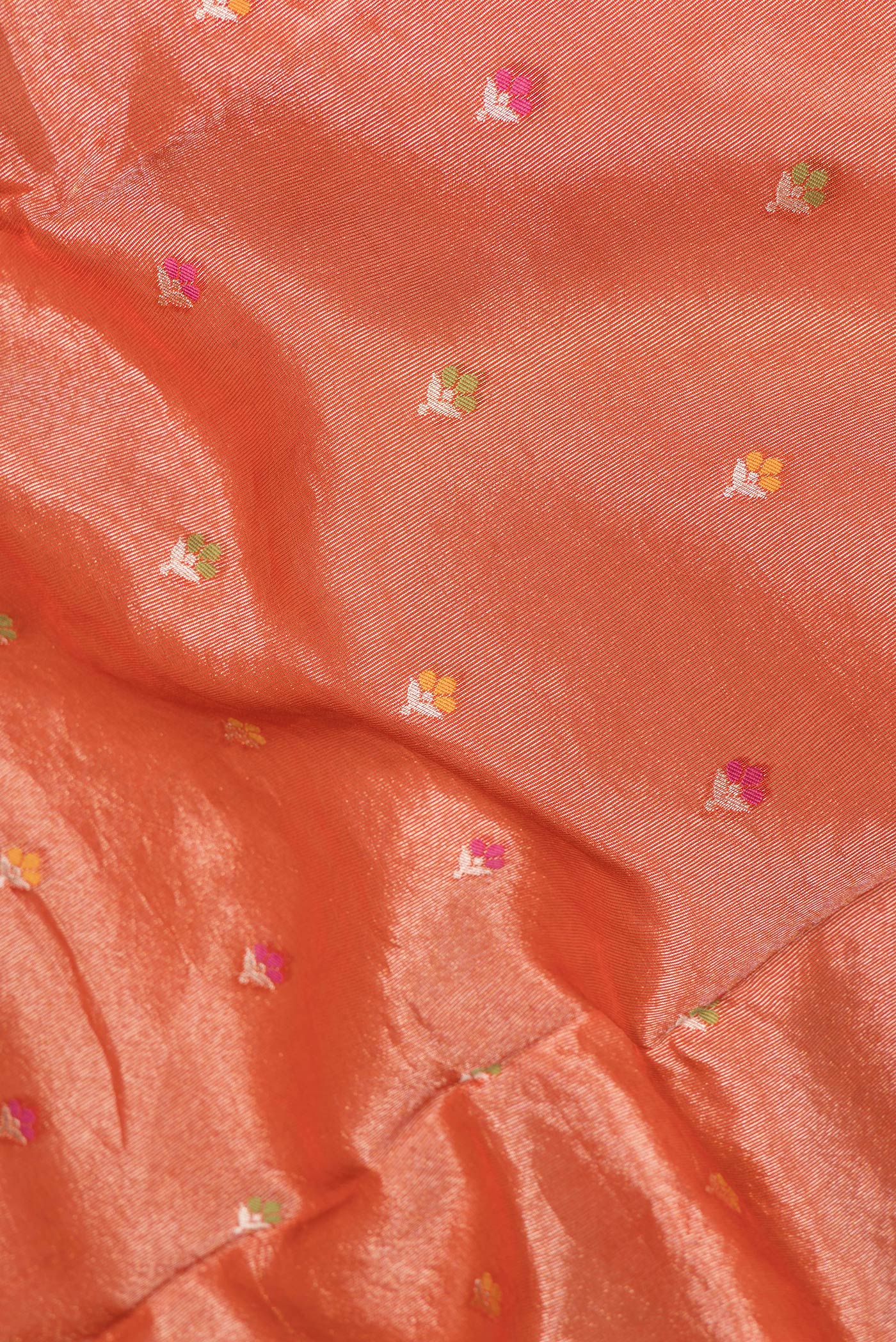 Close up of Orange Dual Tone Organza Silk Saree with Zari And Thread Butta on the body and Fancy Border.  displaying folds