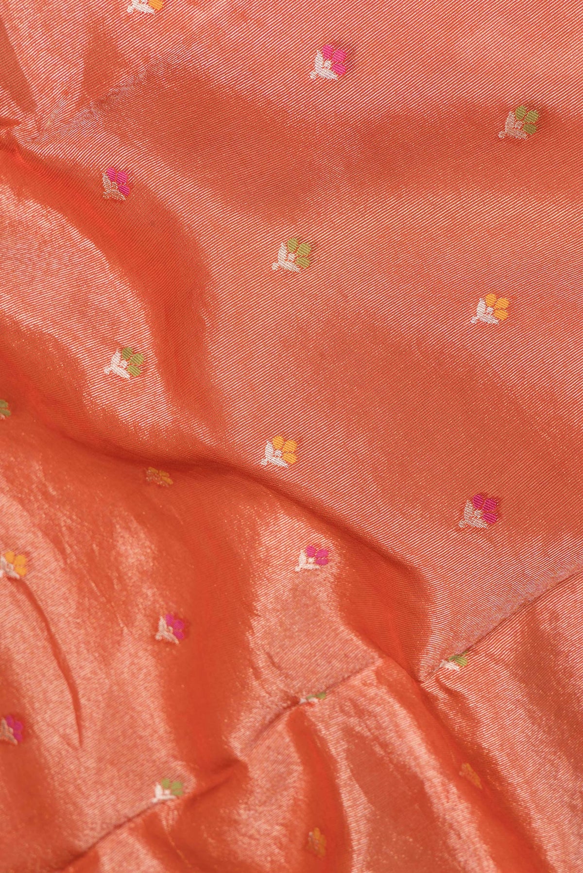 Close up of Orange Dual Tone Organza Silk Saree with Zari And Thread Butta on the body and Fancy Border.  displaying folds