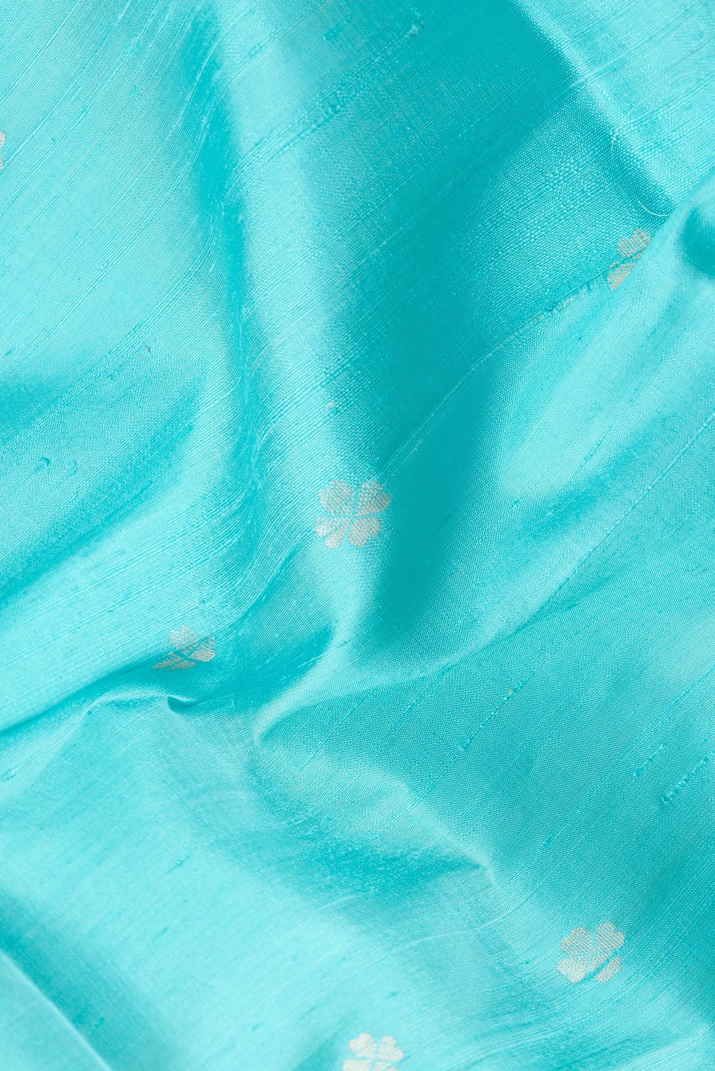 Close up of Sky Blue Dual Tone Raw Silk Saree with Zari Butta on the body and Zari Border.  displaying folds