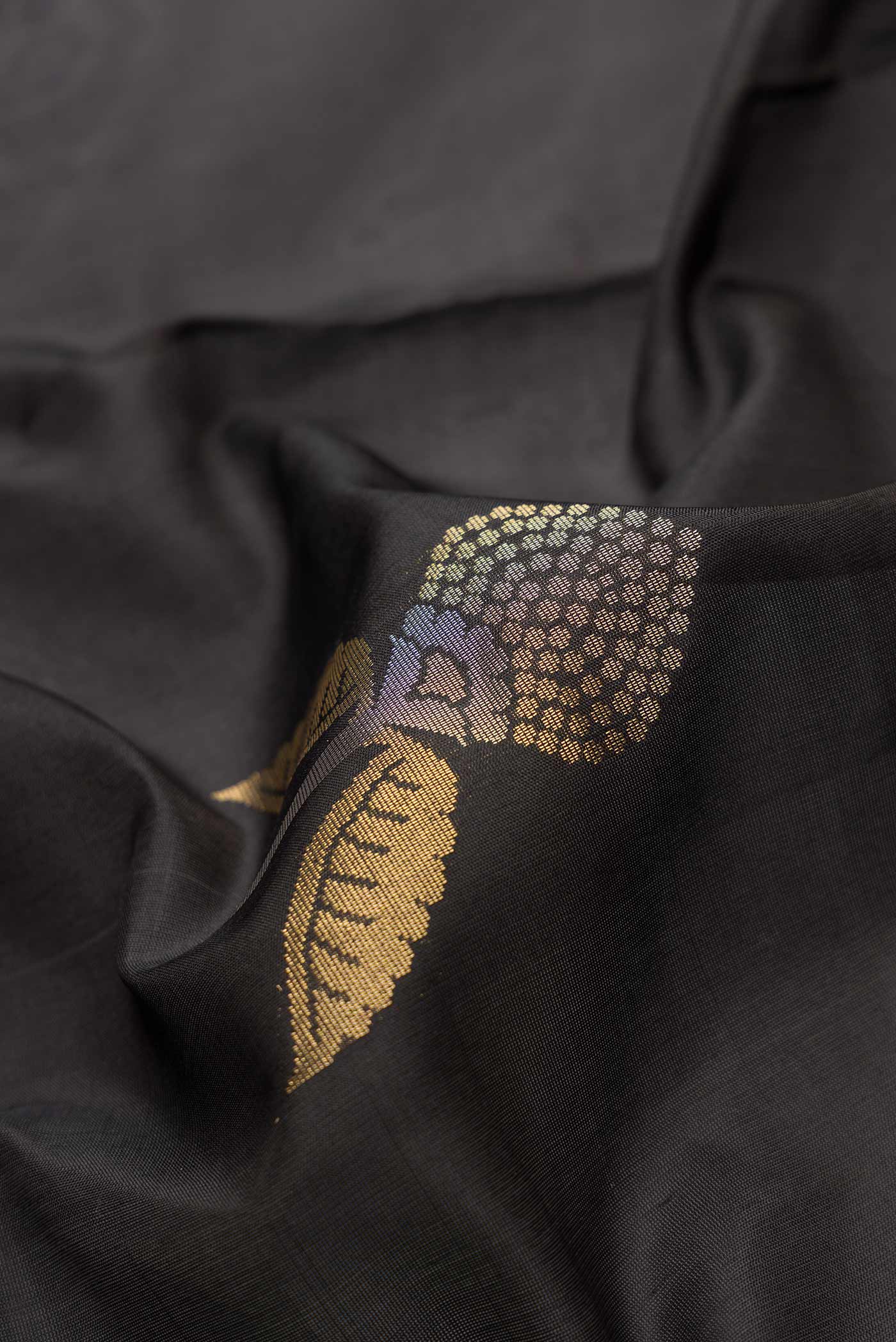 Close up of Black Dual Tone Soft Silk Saree with Zari Butta on the body and Zari Border.  displaying folds