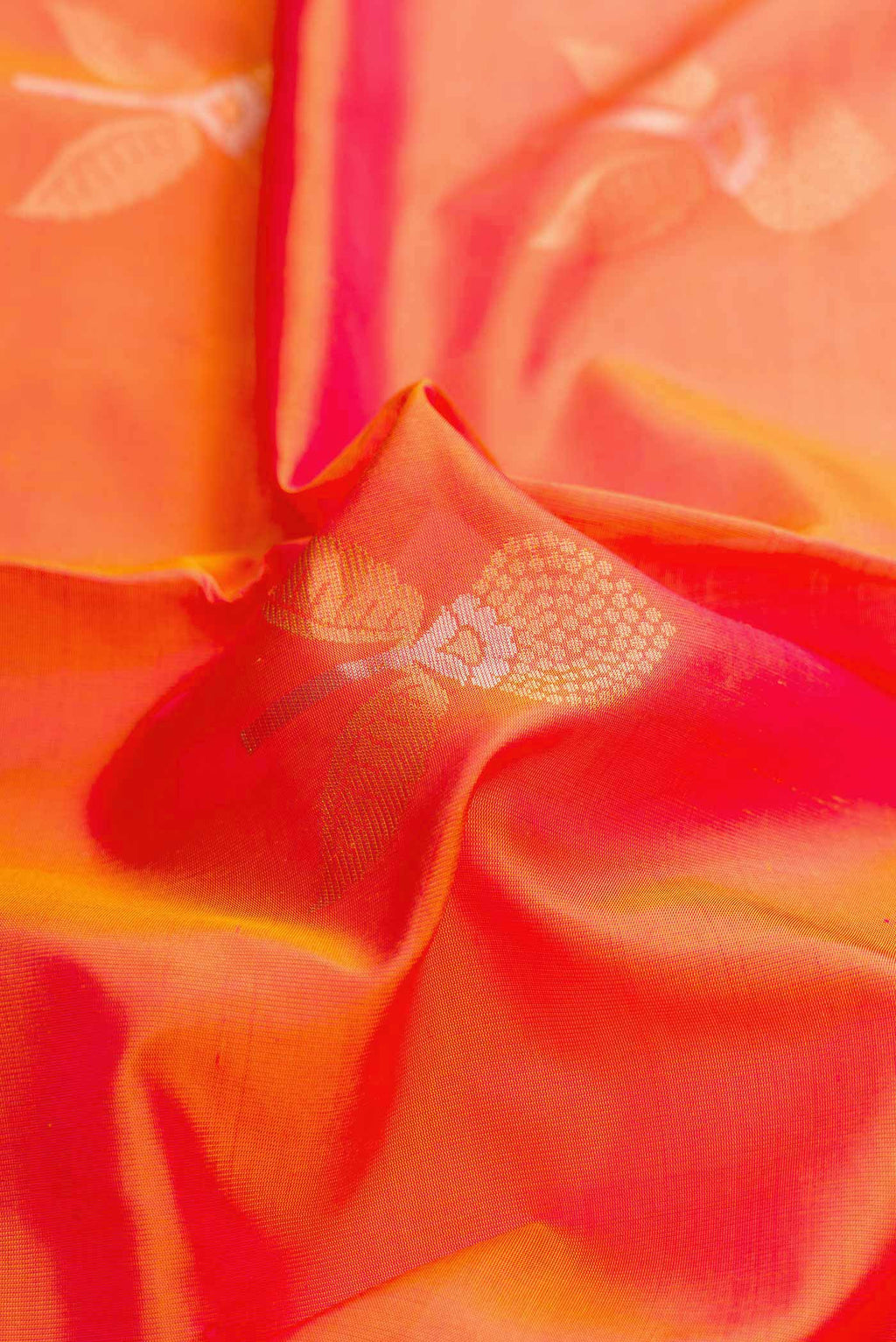 Close up of Orange Dual Tone Soft Silk Saree with Zari Butta on the body and Zari Border displaying folds