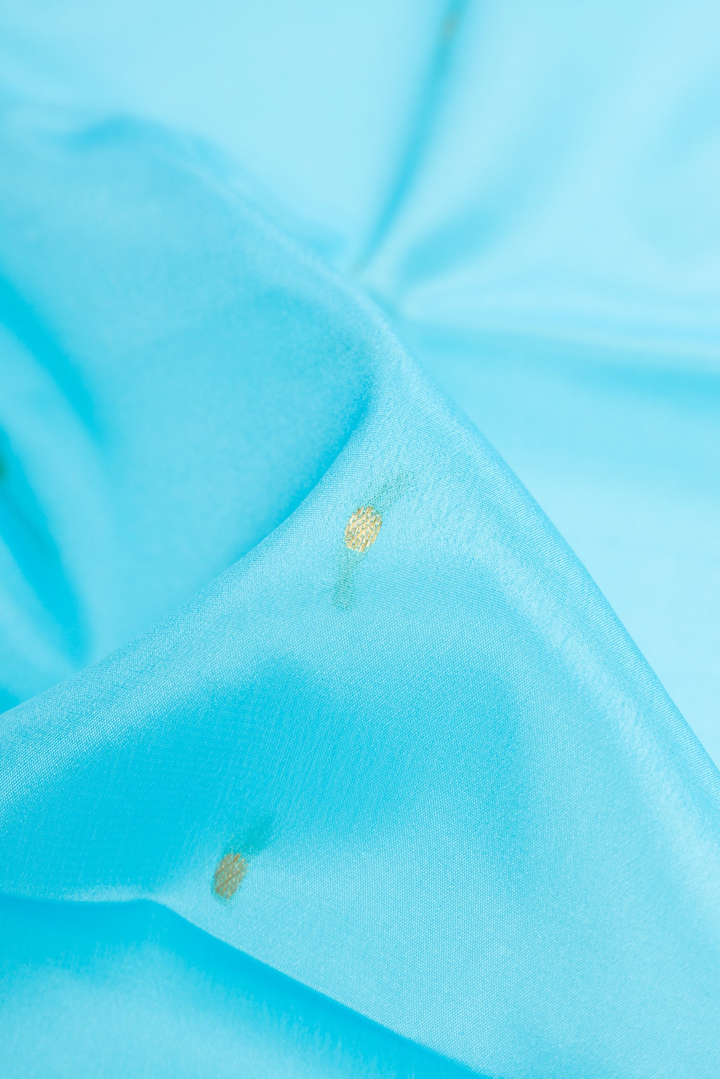 Close up of Sky Blue Mysore Crepe Saree with Zari Butta on the body and Zari Border.  displaying folds