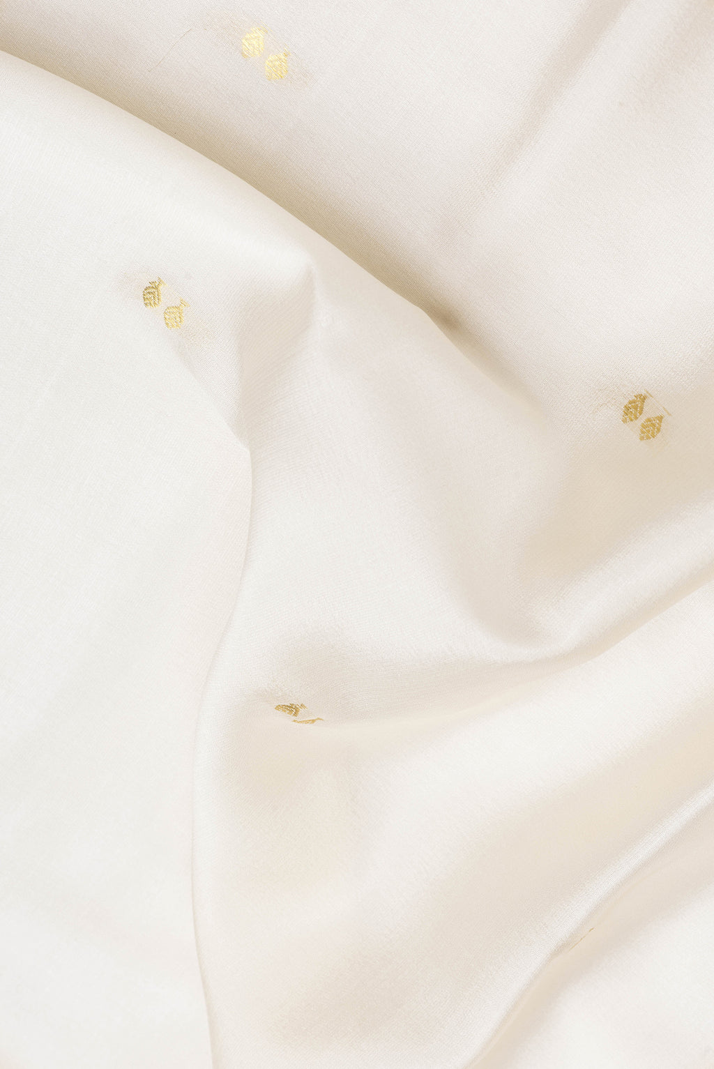 Close up of Beige Dual Tone Mysore Silk Saree with Zari Butta on the body and Zari Border.  displaying folds
