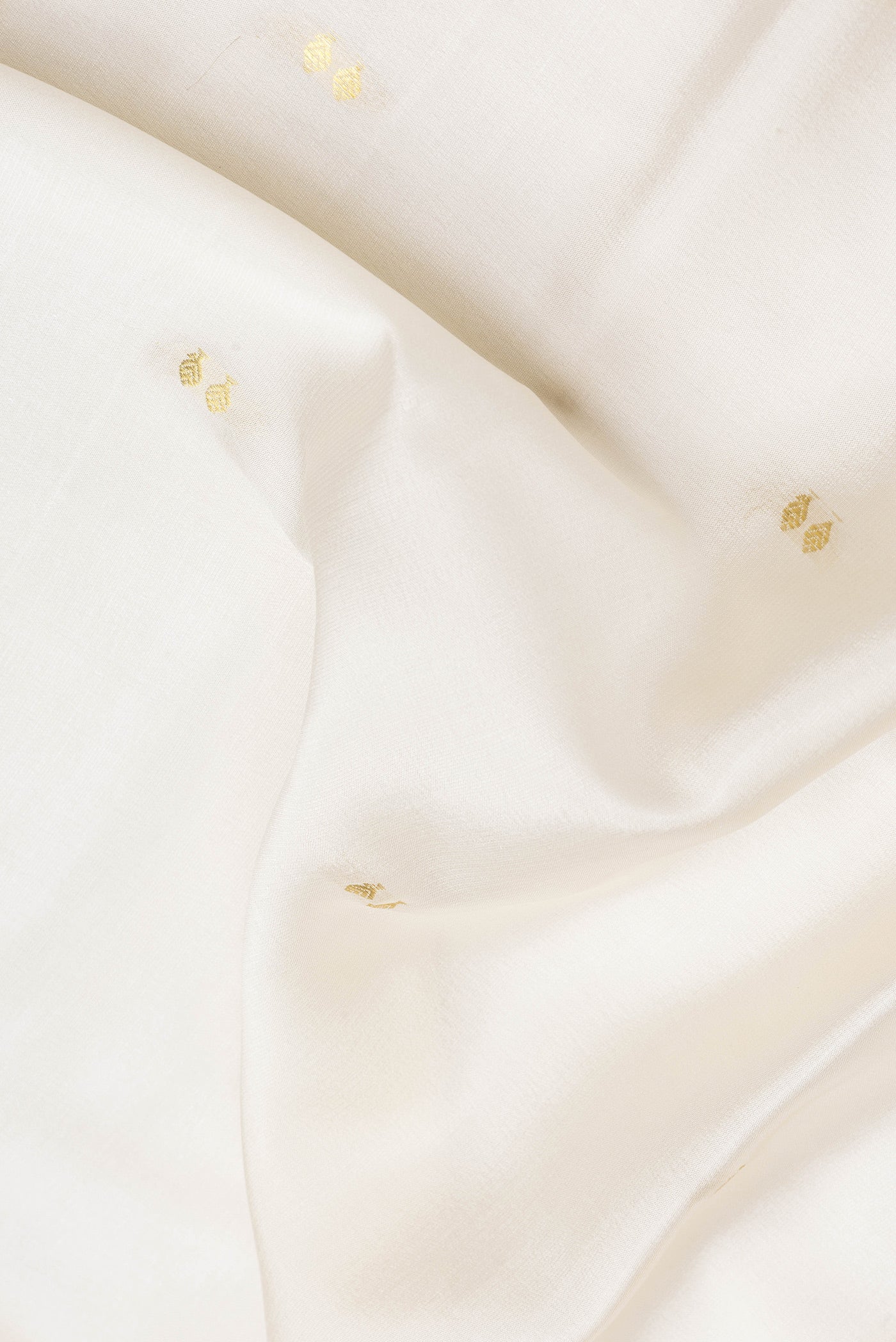 Close up of Beige Dual Tone Mysore Silk Saree with Zari Butta on the body and Zari Border.  displaying folds