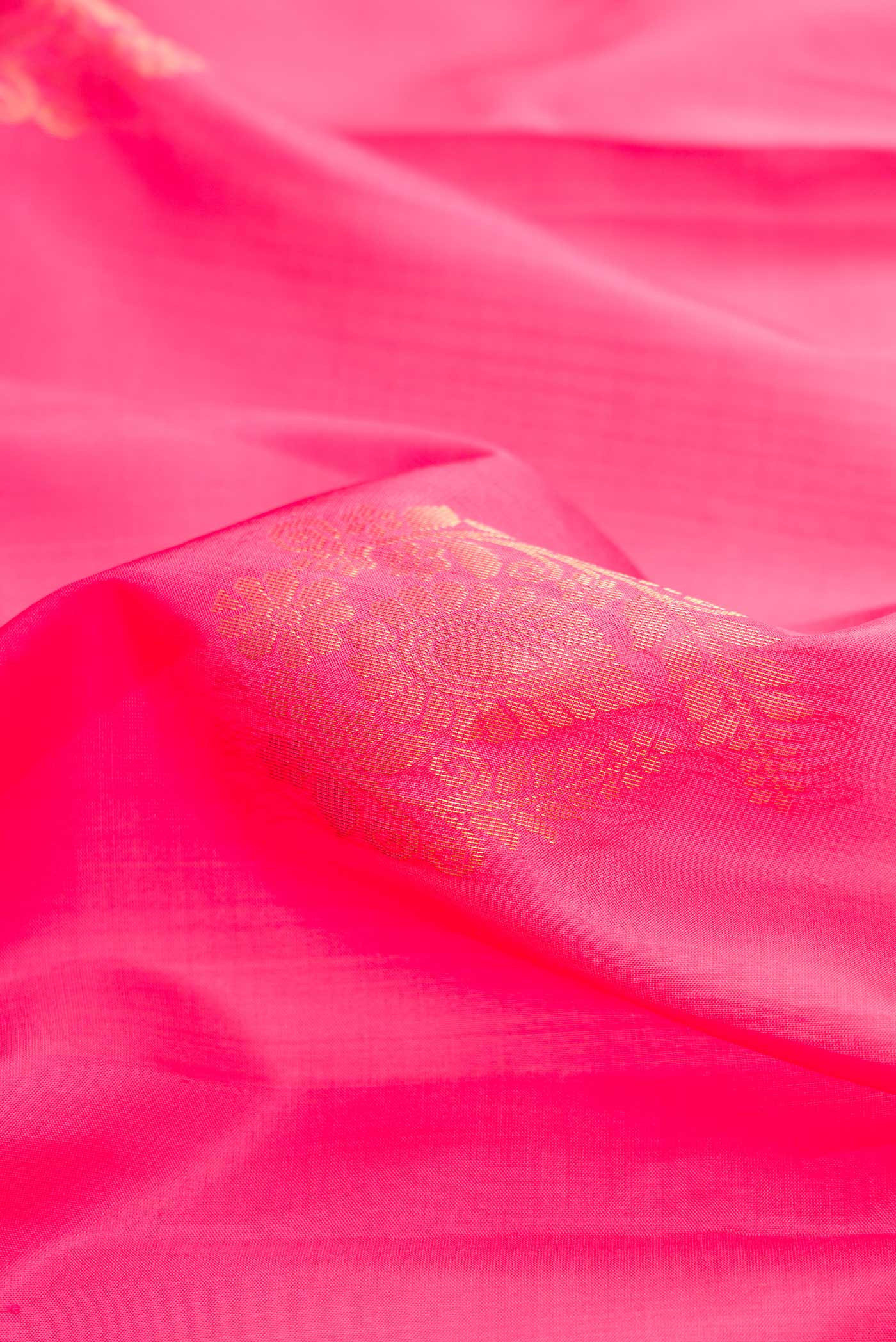 Close up of Pink Dual Tone Soft Silk Saree with Zari Butta on the body and Zari Border.  displaying folds