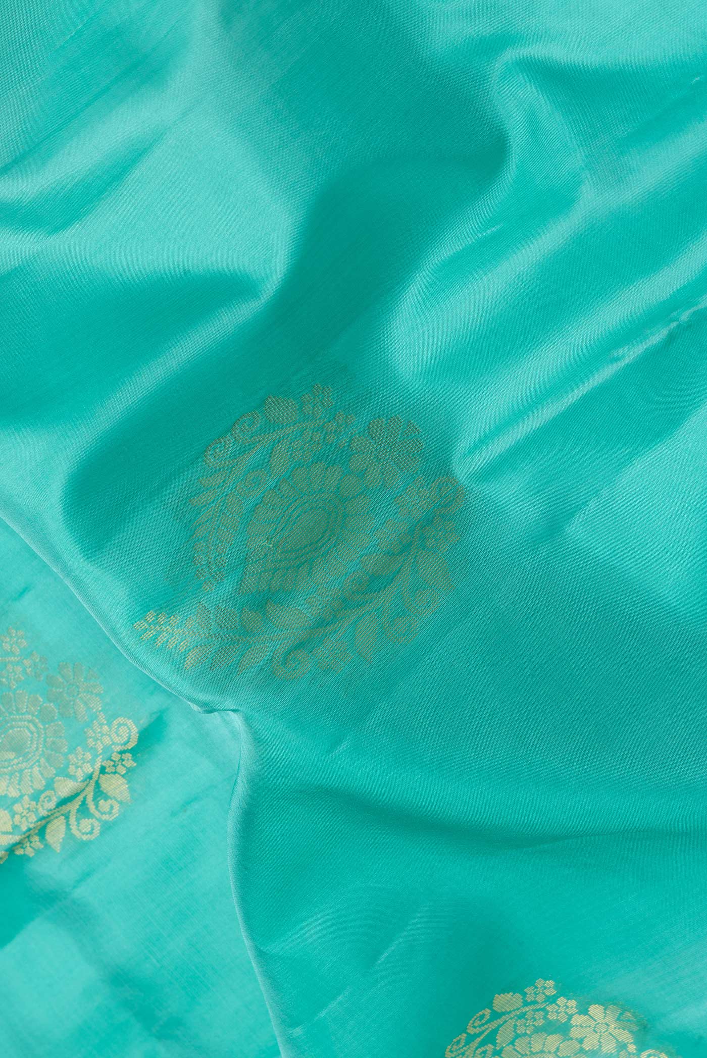 Close up of Sea Green Dual Tone Soft Silk Saree with Zari Butta on the body and Zari Border.  displaying folds