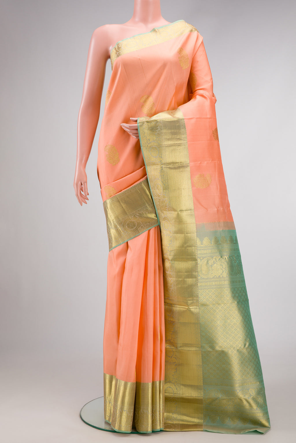 Peach Dual Tone Kanjivaram Silk Saree with Zari Butta on the body and Zari Border.  displayed on a mannequin