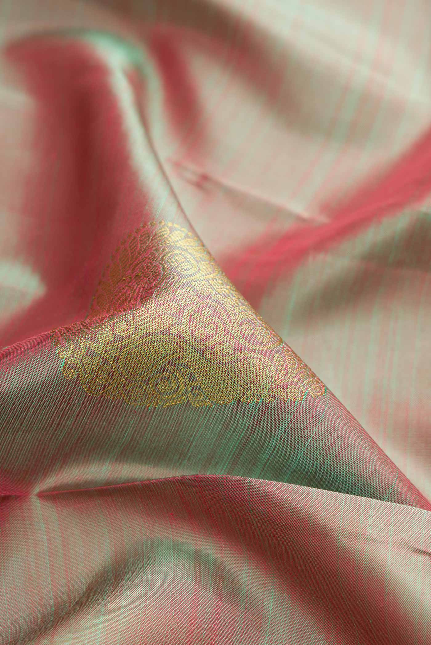 Close up of Green Dual Tone Kanjivaram Silk Saree with Zari Brocade on the body and Zari Border.  displaying folds