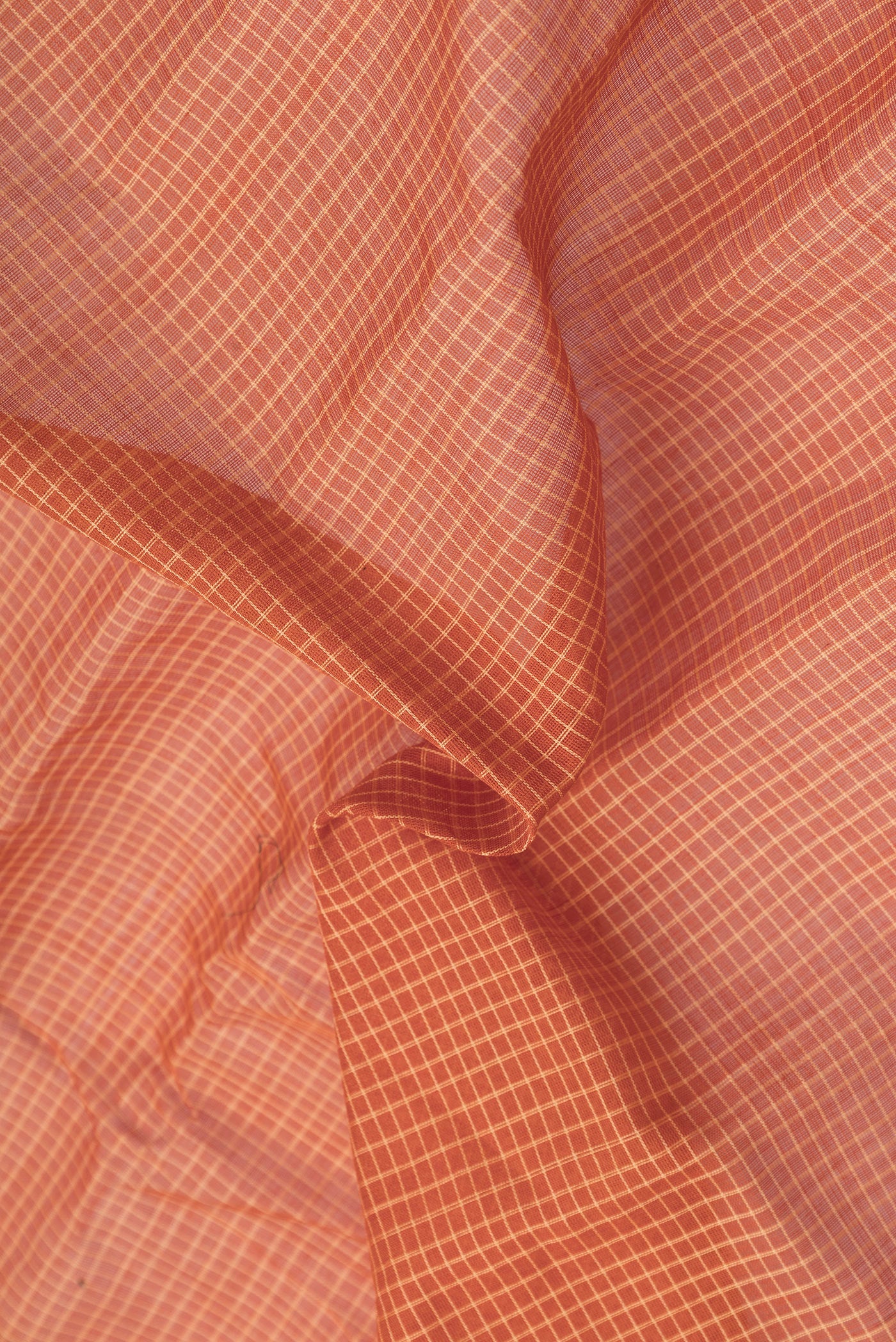 Close up of Orange Dual Tone Gadwal Silk Cotton Saree with Checked design on the body and Zari Border.  displaying folds