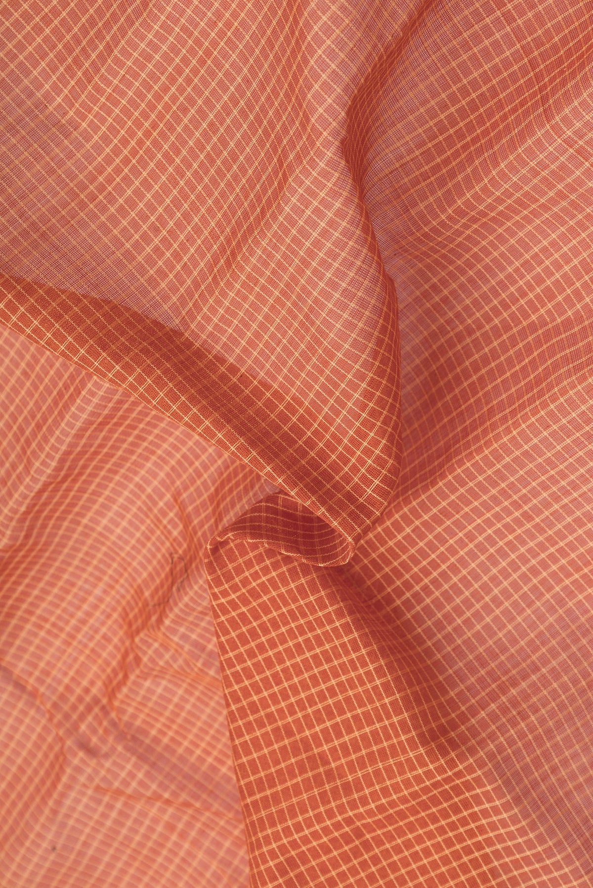 Close up of Orange Dual Tone Gadwal Silk Cotton Saree with Checked design on the body and Zari Border.  displaying folds