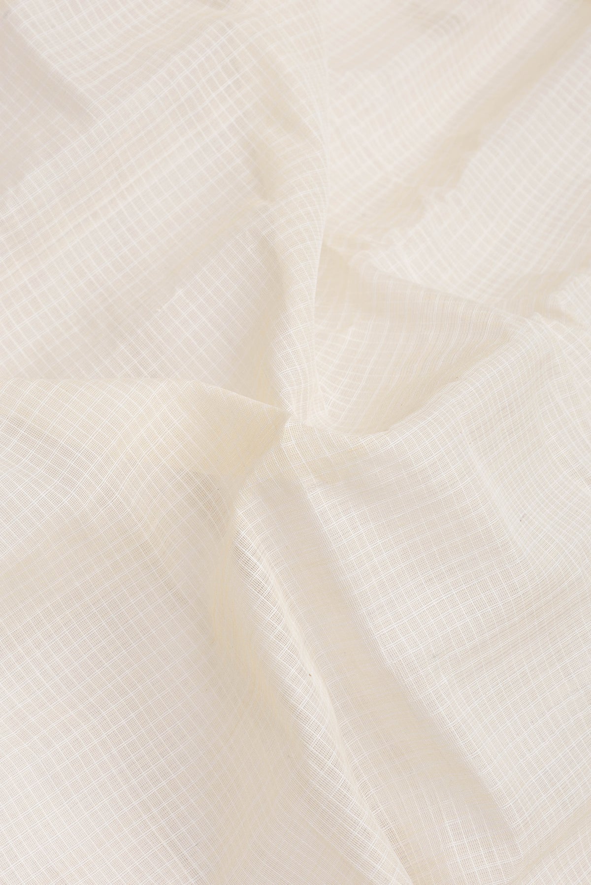 Close up of Off White Dual Tone Kanchipuram Silk Saree with Checked design on the body and Zari Border.  displaying folds
