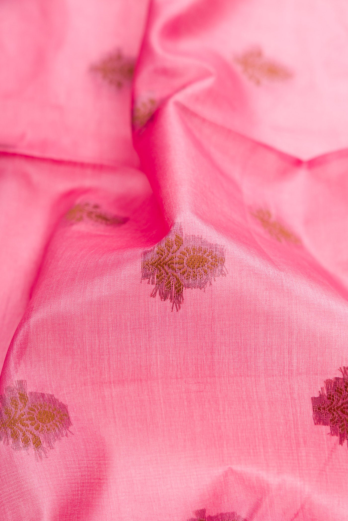 Close up of Pink Tussar Silk Saree with Thread Butta on the body and Fancy Border.  displaying folds