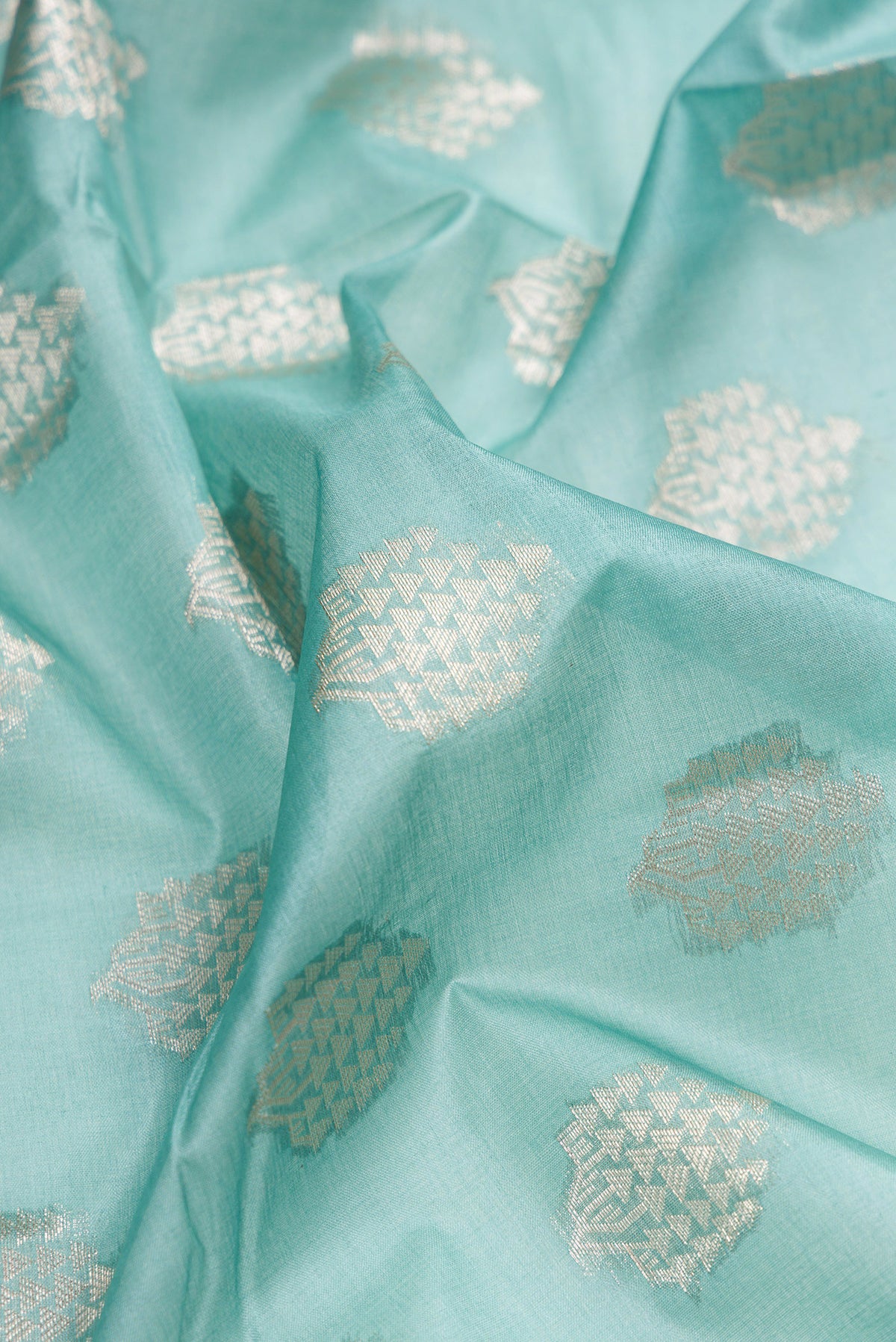 Close up of Sky Blue Tussar Silk Saree with Zari Butta on the body and Zari Border.  displaying folds