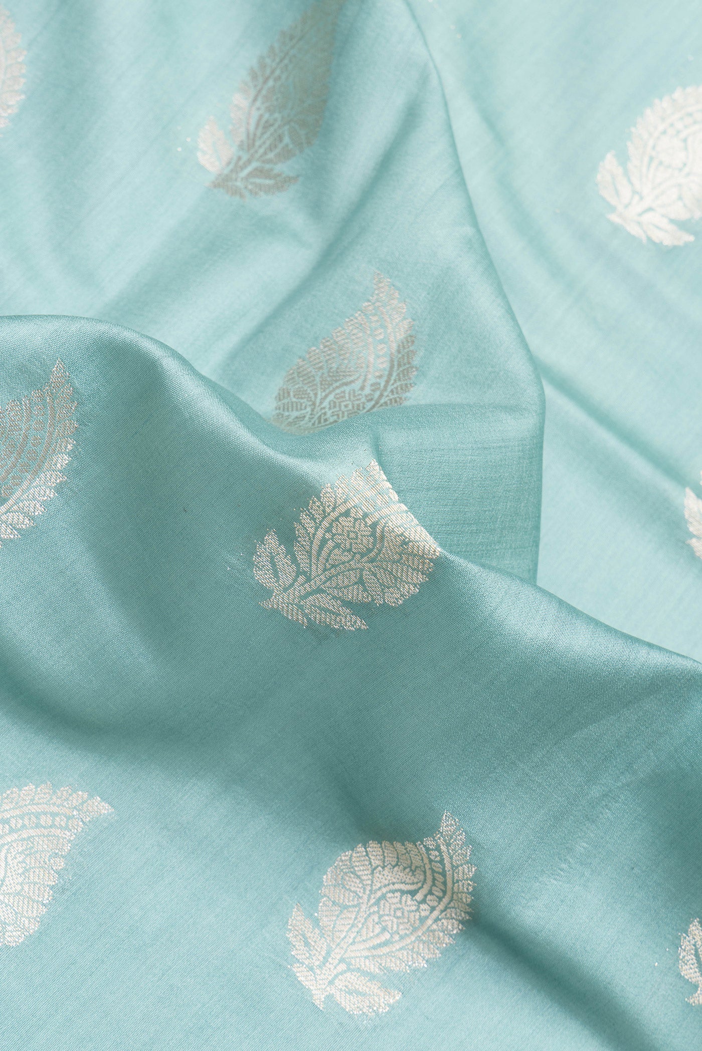 Close up of Light Blue Dual Tone Banarasi Raw Silk Saree with Zari Butta on the body and Zari Border.  displaying folds