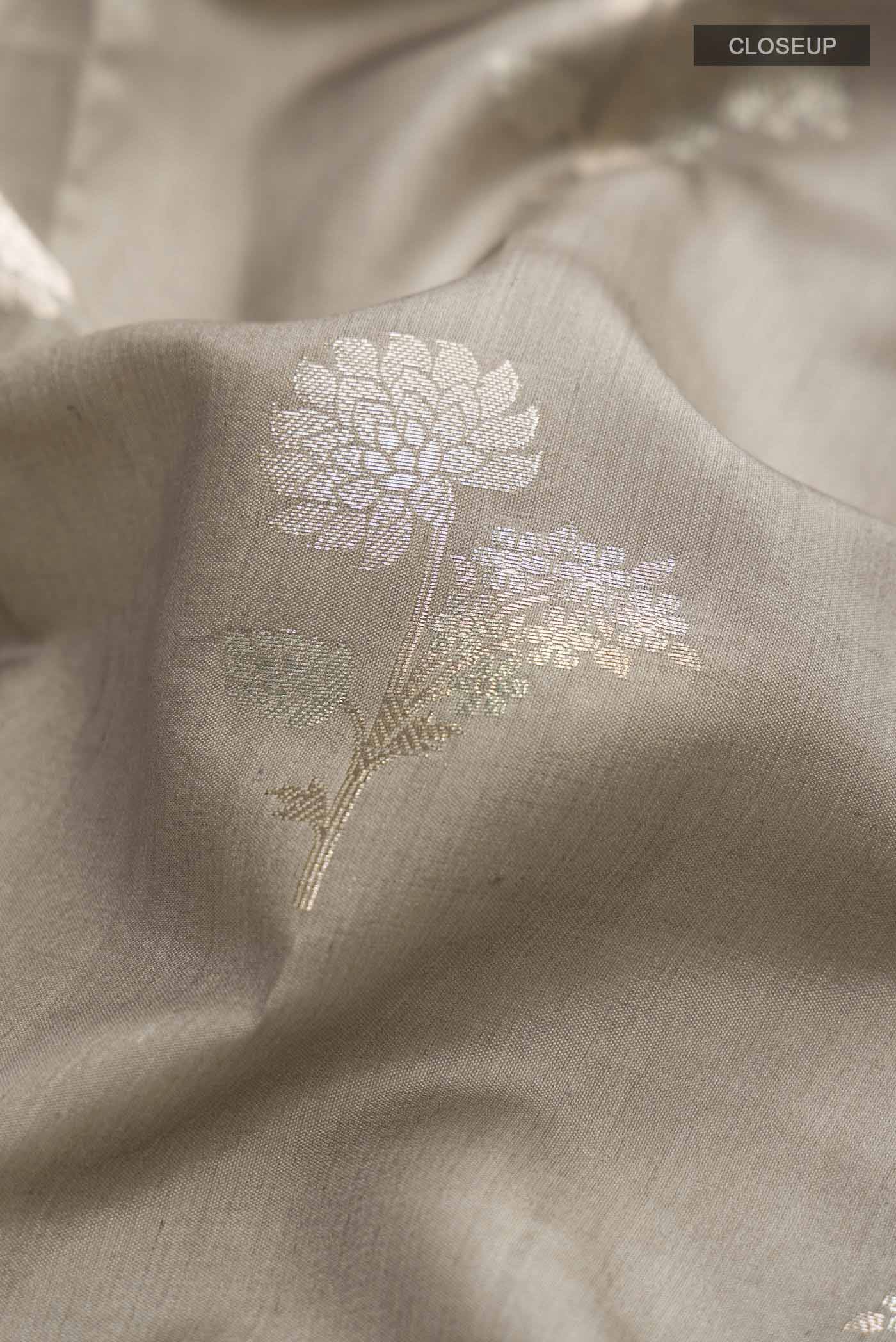 Close up of Grey Banarasi Raw Silk Saree with Zari Butta on the body and Zari Border displaying folds