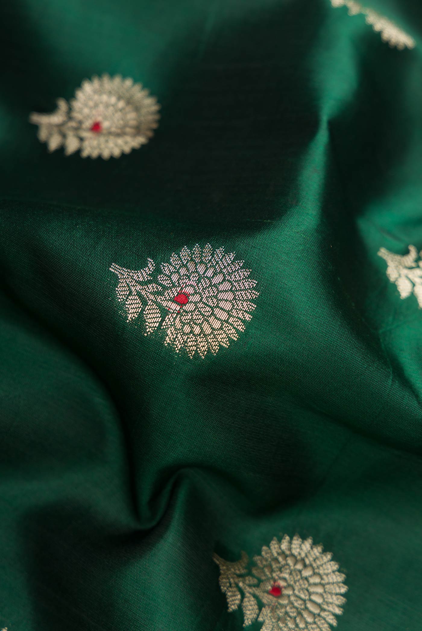 Close up of Bottle Green Dual Tone Tussar Silk Saree with Zari Butta on the body and Zari Border.  displaying folds