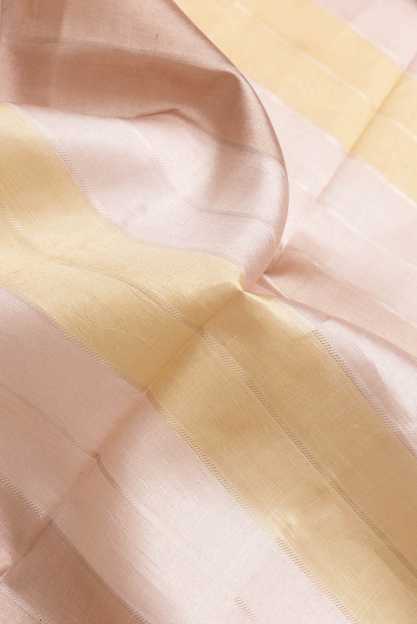 Close up of Rose Gold Dual Tone Tussar Silk Saree with Stripes on the body and Zari Border.  displaying folds