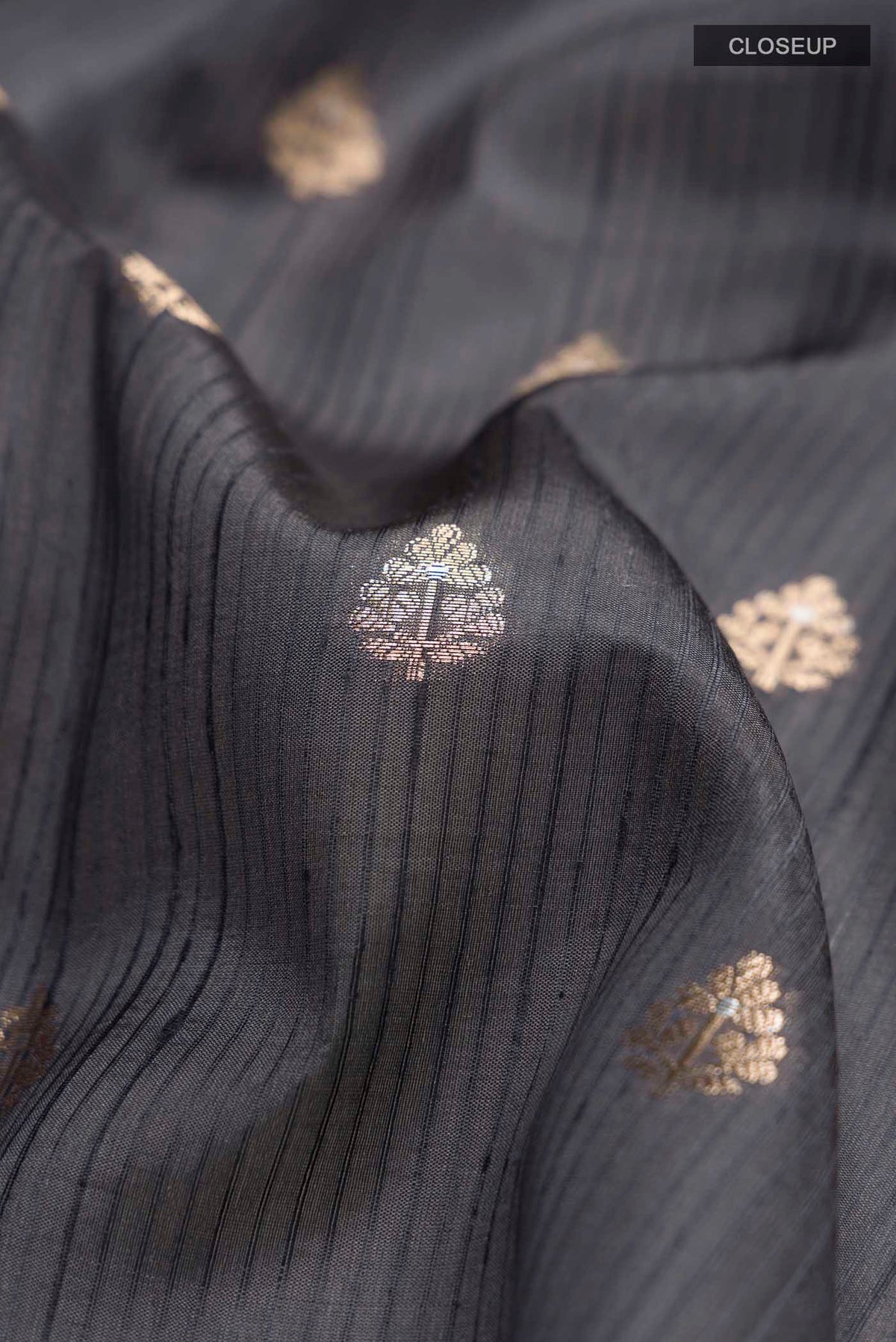 Close up of Grey Banarasi Raw Silk Saree with Zari Butta on the body and Zari Border displaying folds