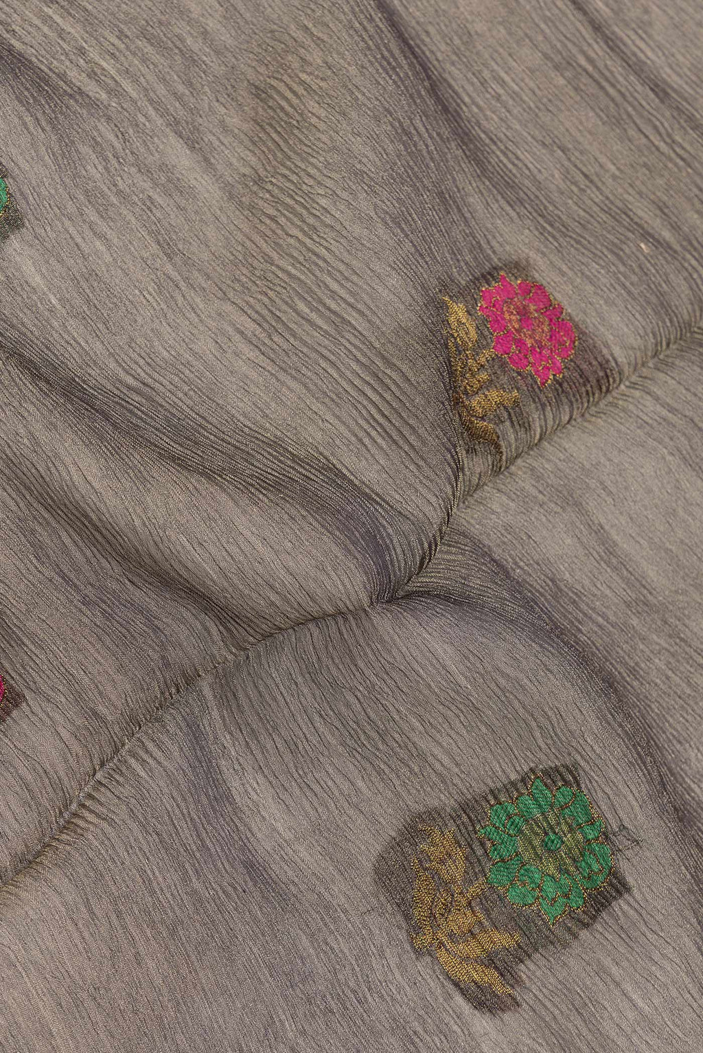Close up of Grey Dual Tone Organza Silk Saree with Zari And Thread Butta on the body and Zari Border.  displaying folds