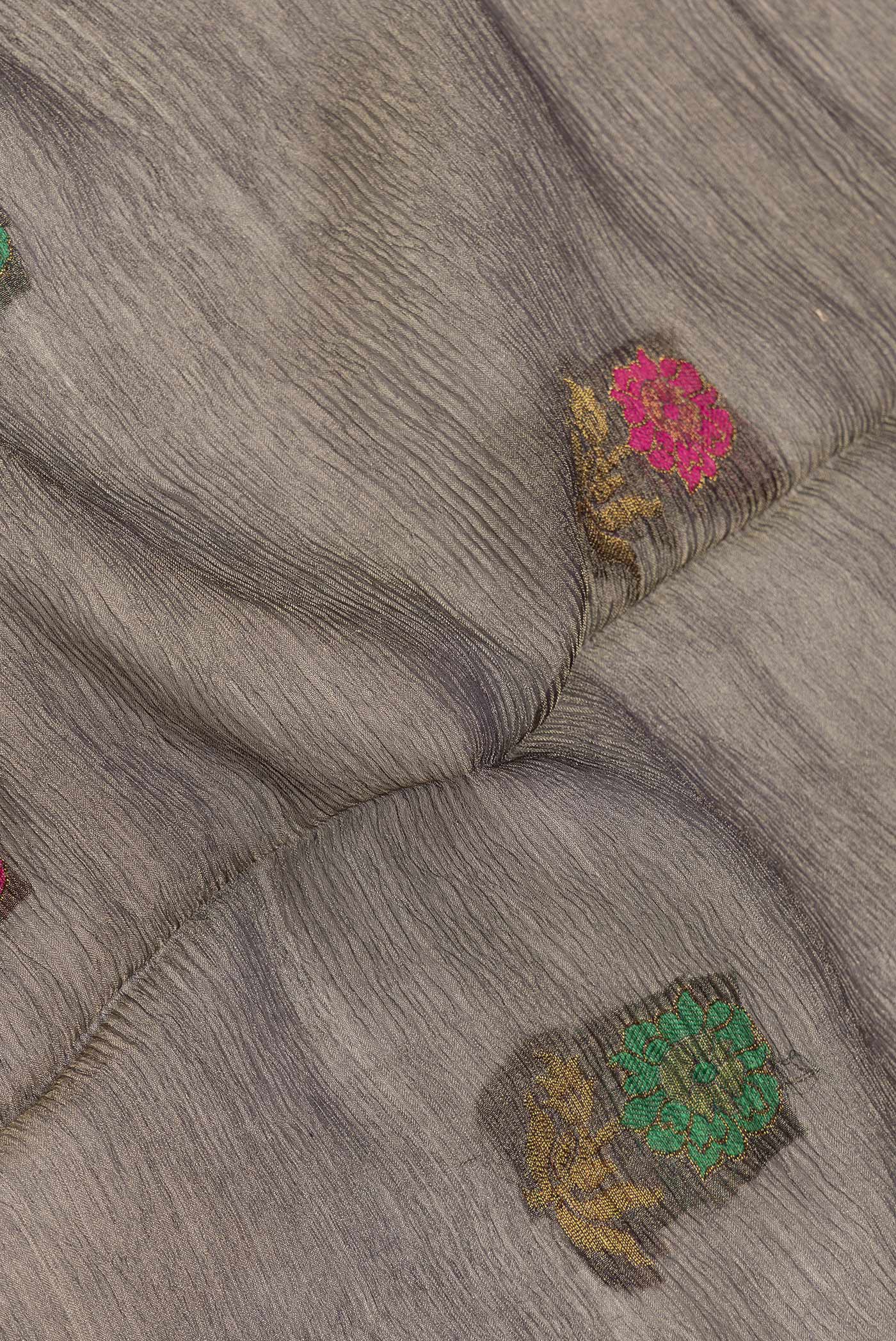 Close up of Grey Dual Tone Organza Silk Saree with Zari And Thread Butta on the body and Zari Border.  displaying folds