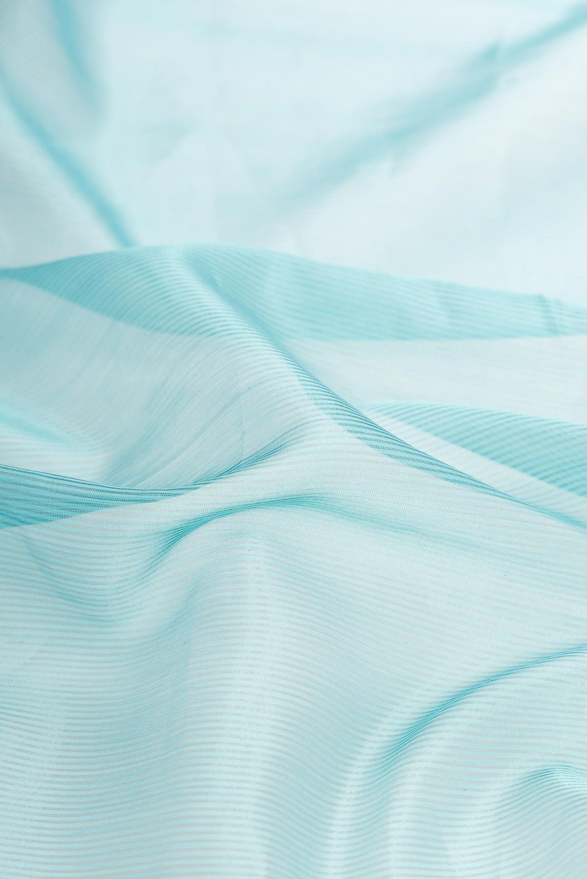 Close up of Sky Blue Dual Tone Maheshwari Silk Saree with Stripes on the body and Zari Border displaying folds