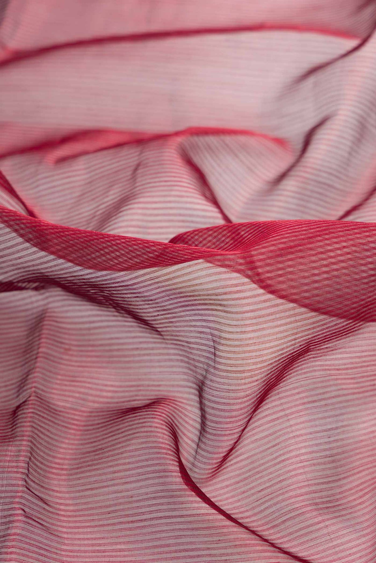 Close up of Maroon Dual Tone Maheshwari Silk Saree with Stripes on the body and Zari Border displaying folds