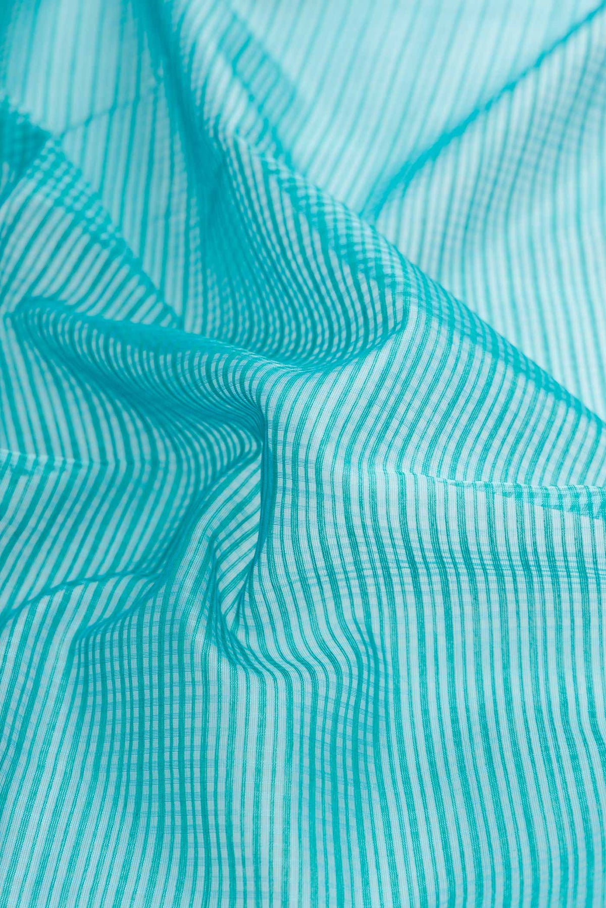 Close up of Blue Dual Tone Maheshwari Silk Saree with Checked design on the body and Zari Border displaying folds