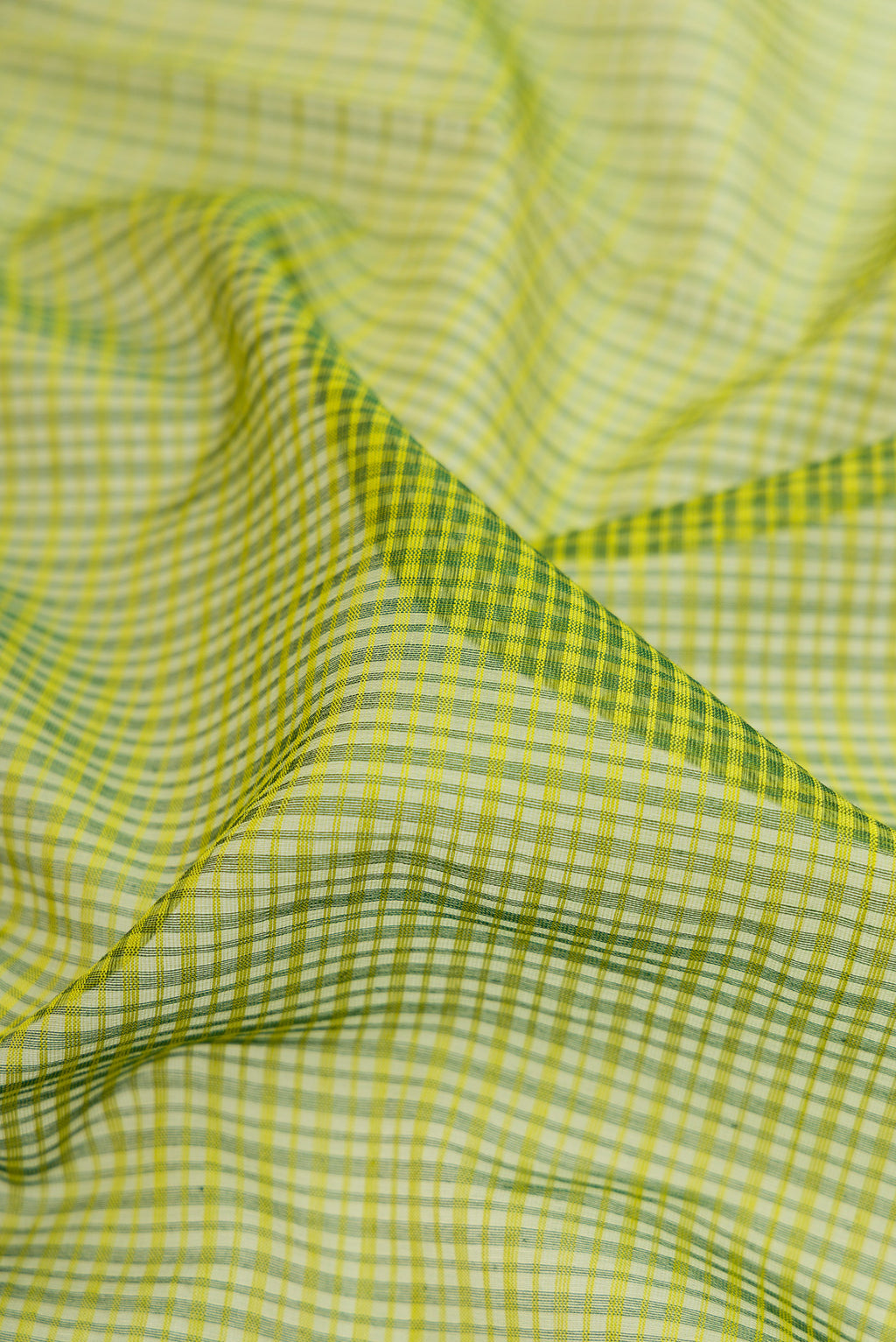 Close up of Green Maheshwari Silk Cotton Saree with Stripes on the body and Zari Border.  displaying folds