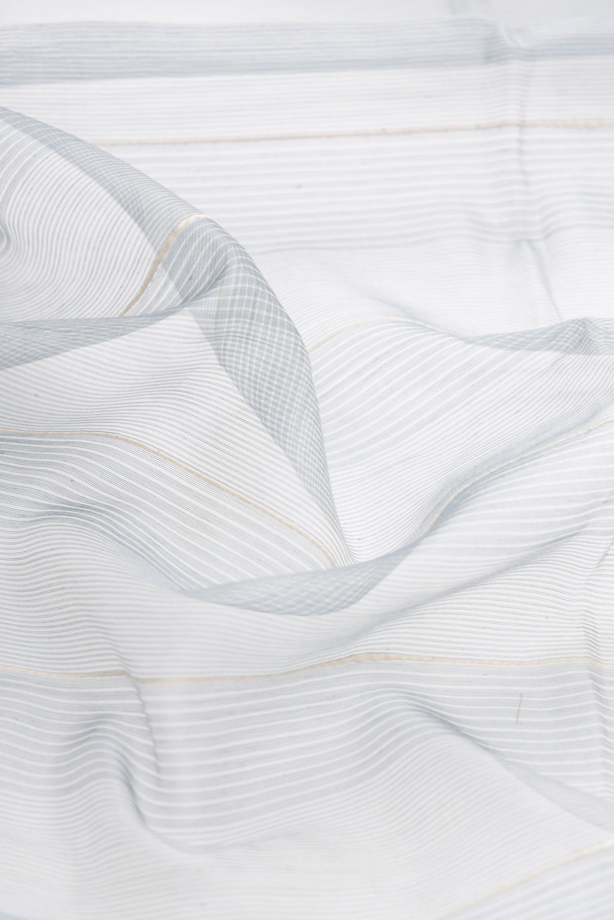 Close up of Grey Dual Tone Silk Cotton Saree with Stripes on the body and Zari Border displaying folds