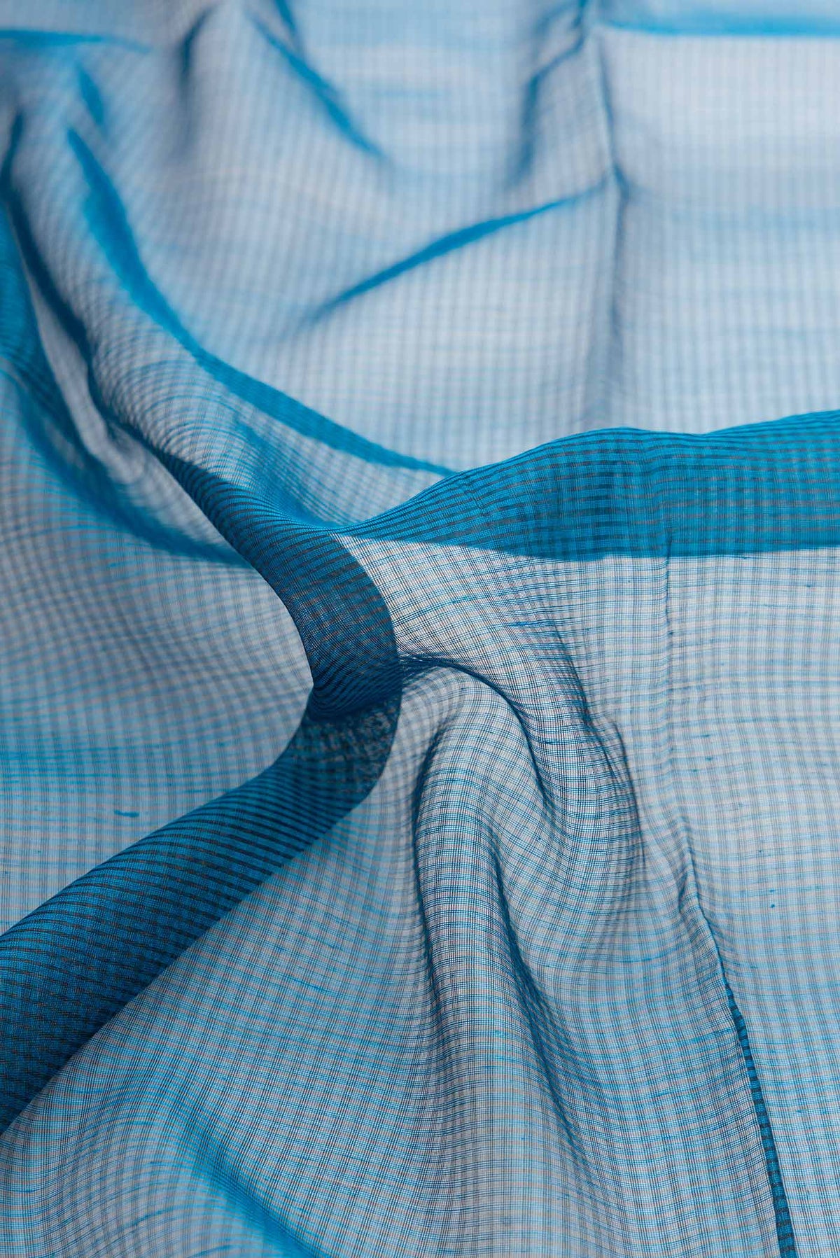 Close up of Maya Blue Dual Tone Silk Cotton Saree with Stripes on the body and Zari Border displaying folds