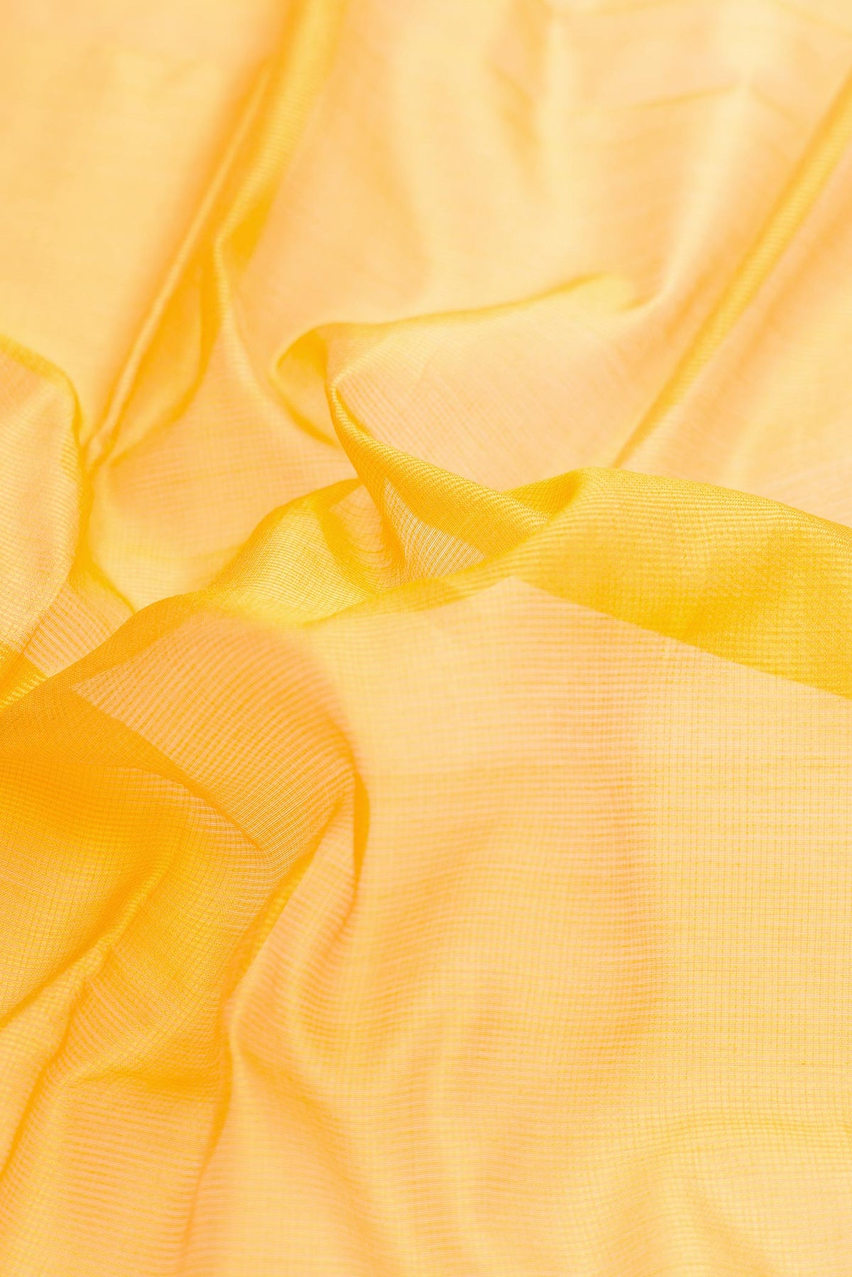 Close up of Yellow Dual Tone Maheshwari Silk Saree with Checked design on the body and Zari Border displaying folds