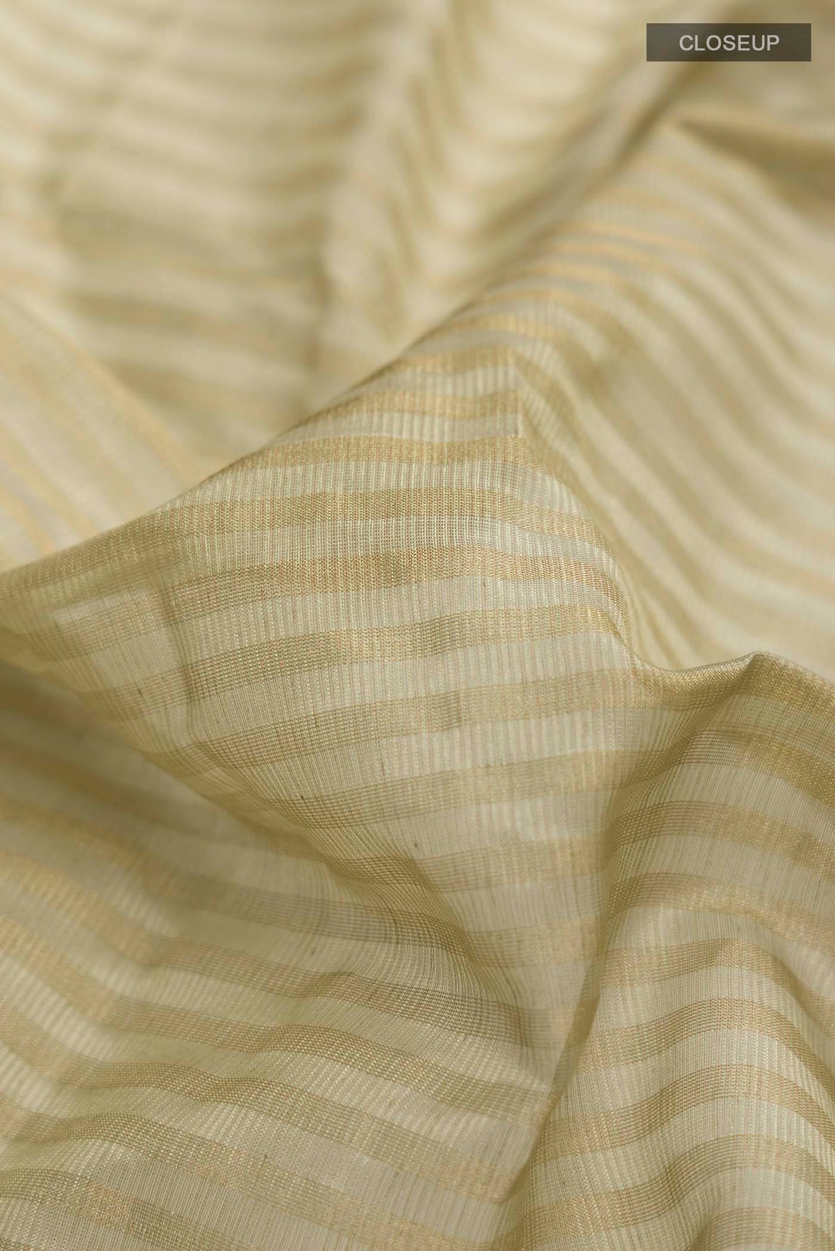 Close up of Sage Green Maheshwari Silk Saree with Stripes on the body and Zari Border displaying folds