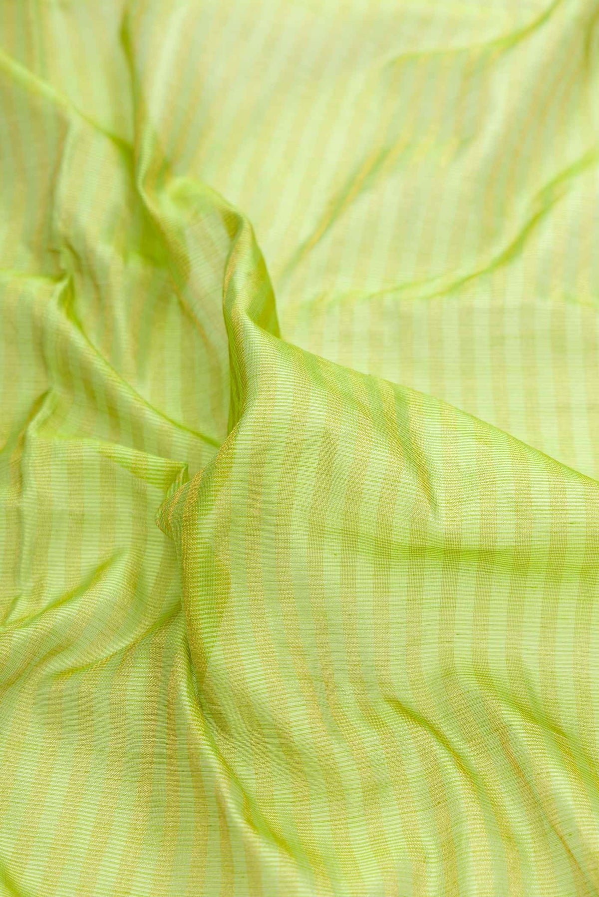 Close up of Parrot Green Dual Tone Maheshwari Silk Saree with Checked design on the body and Zari Border displaying folds