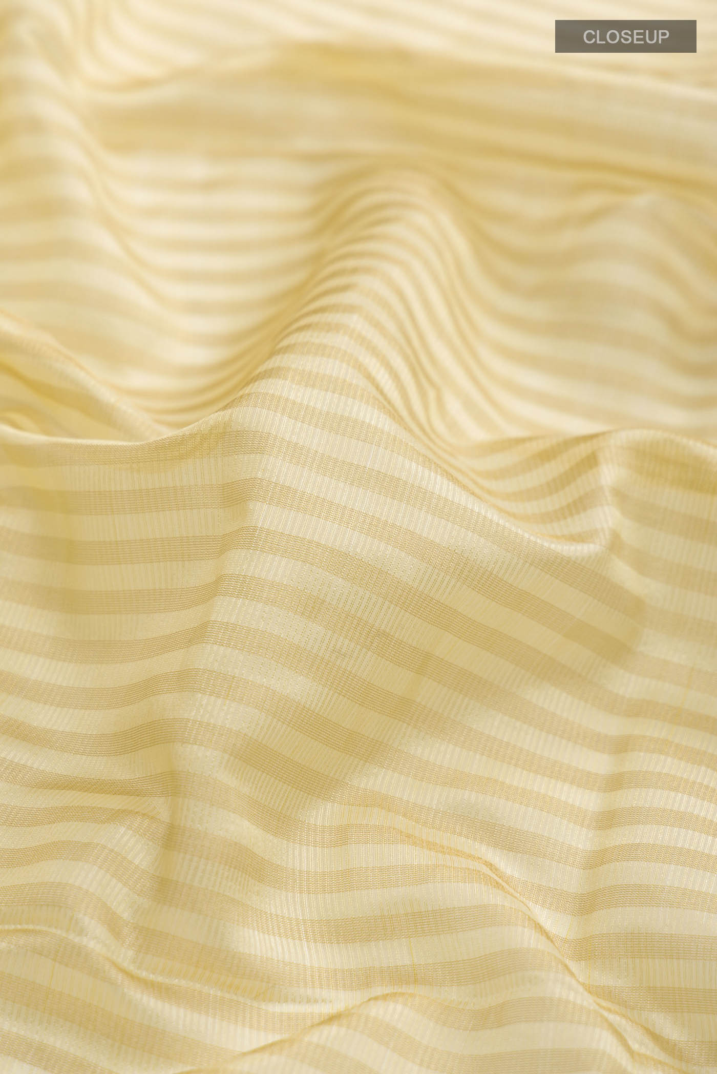 Close up of Cream Banarasi Raw Silk Saree with Stripes on the body and Zari Border displaying folds