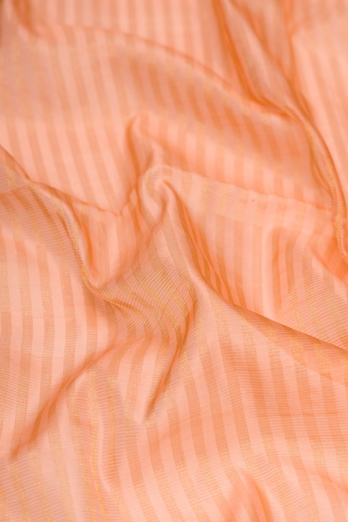 Close up of Golden Peach Dual Tone Maheshwari Silk Saree with Stripes on the body and Zari Border.  displaying folds