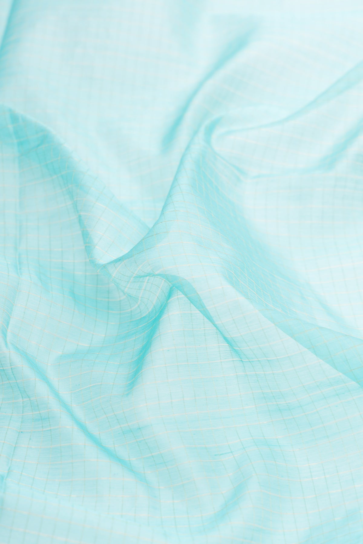 Close up of Sky Blue Dual Tone Maheshwari Silk Saree with Checked design on the body and Zari Border.  displaying folds