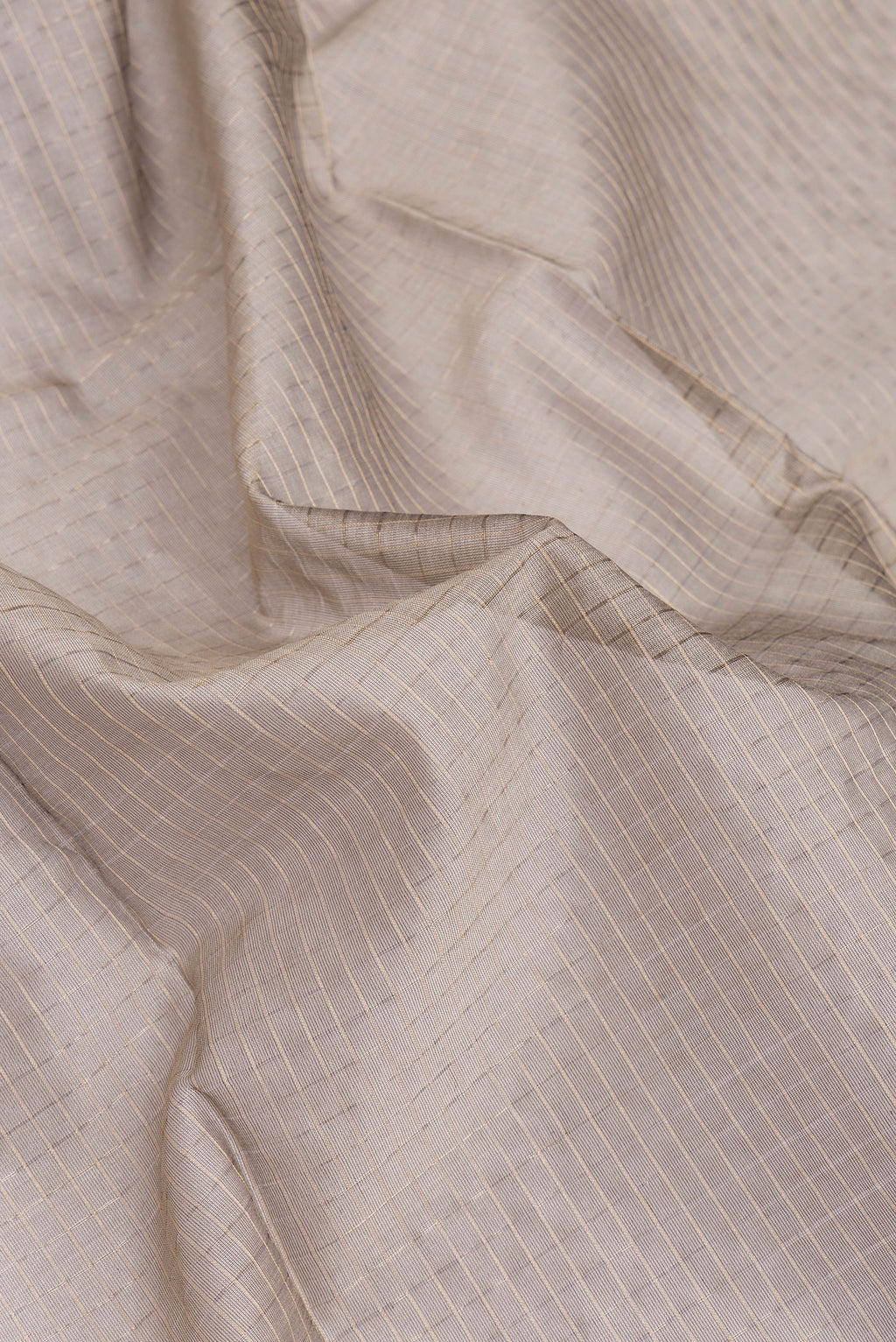Close up of Grey Dual Tone Maheshwari Silk Cotton Saree with Checked design on the body and Zari Border.  displaying folds