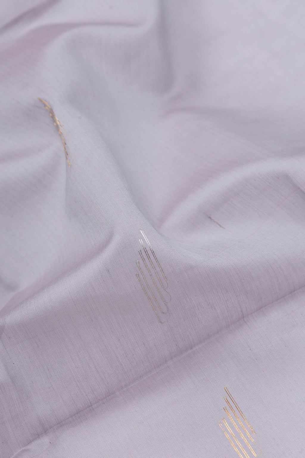 Close up of Grey Dual Tone Maheshwari Silk Saree with Zari Butta on the body and Zari Border.  displaying folds
