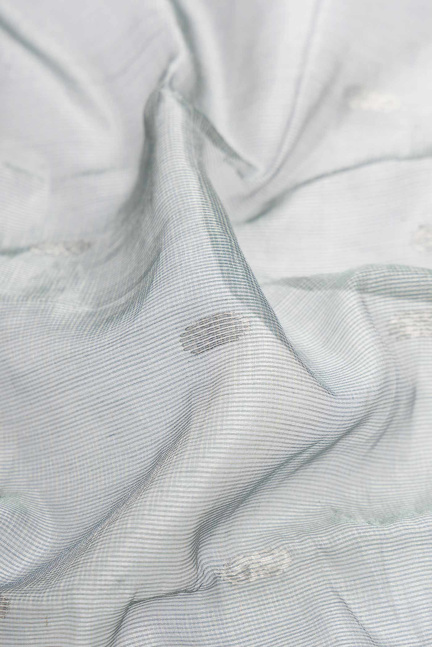Close up of Grey Dual Tone Kota Silk Saree with Zari Butta on the body and Zari Border displaying folds