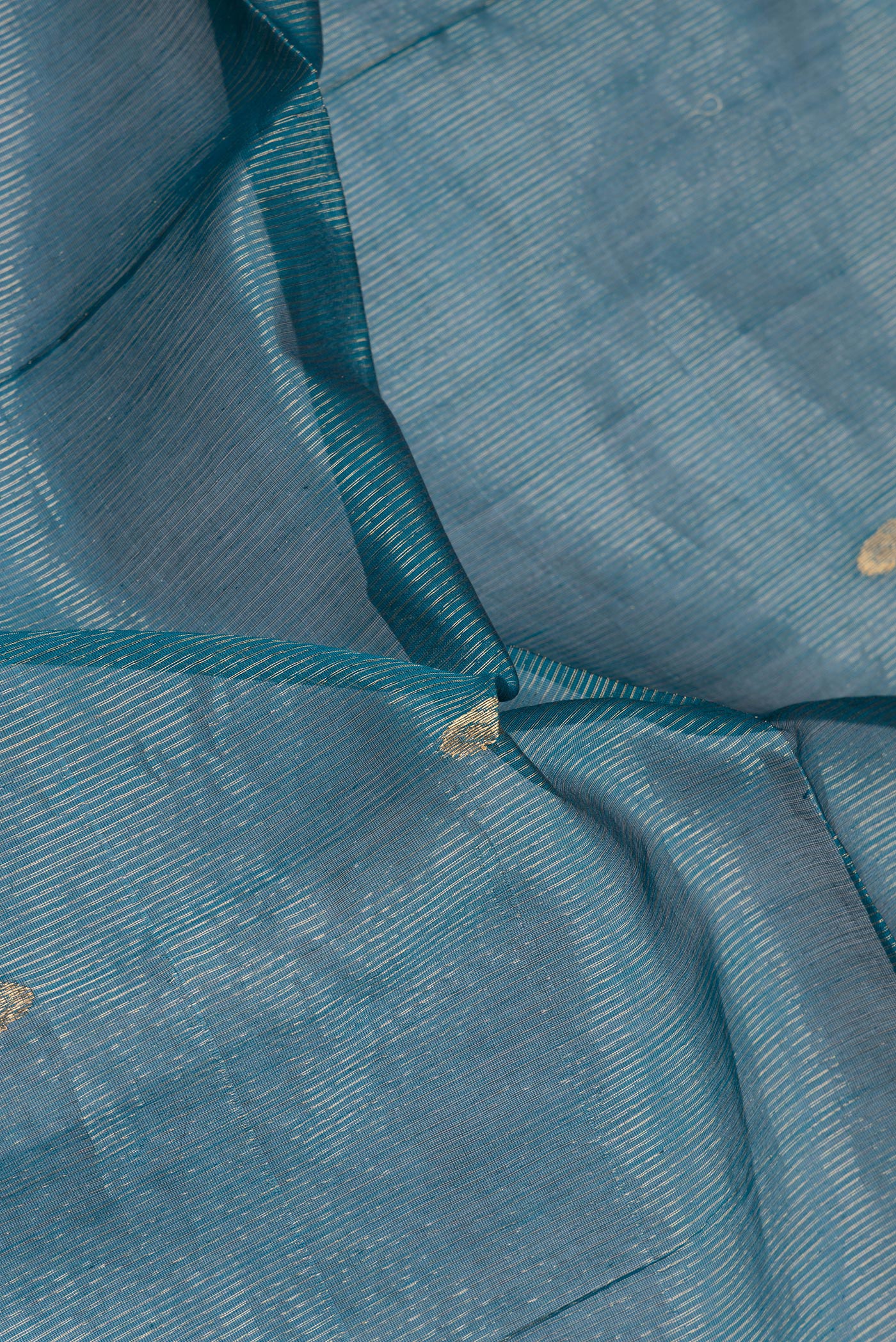 Close up of Peacock Blue Dual Tone Maheshwari Silk Cotton Saree with Stripes on the body and Zari Border.  displaying folds