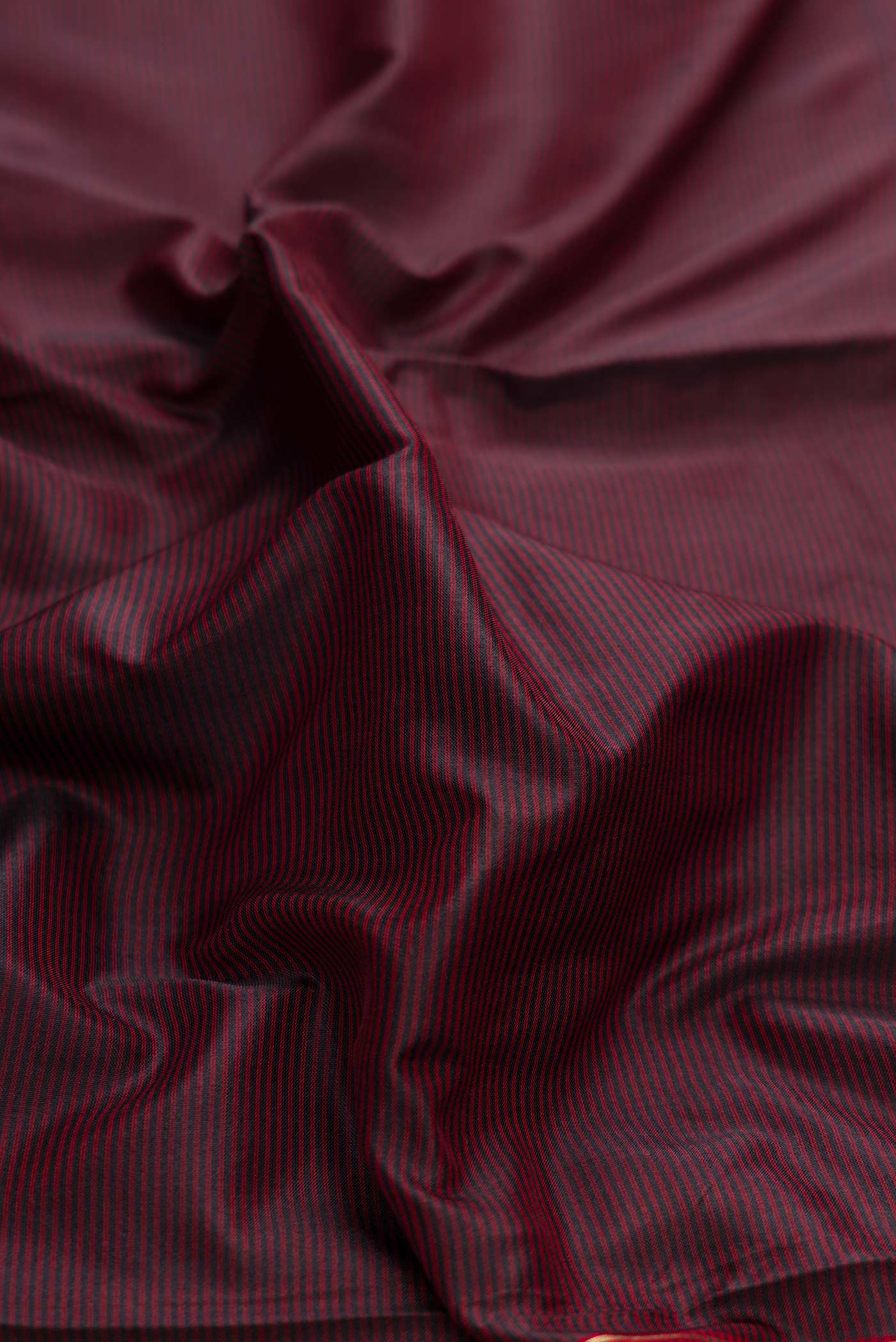 Close up of Brown Dual Tone Maheshwari Silk Saree with Stripes on the body and Zari Border displaying folds