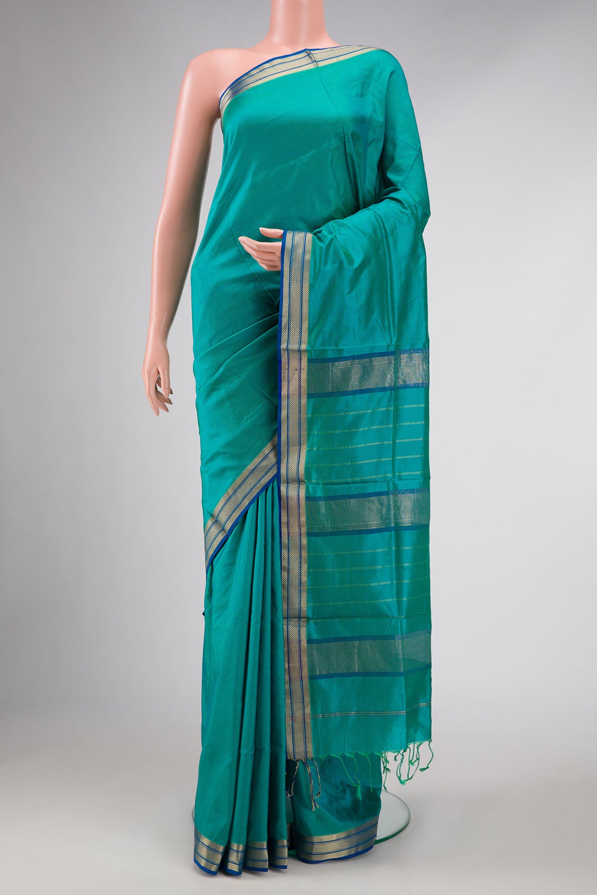 Green Dual Tone Maheshwari Silk Saree with Stripes on the body and Zari Border displayed on a mannequin