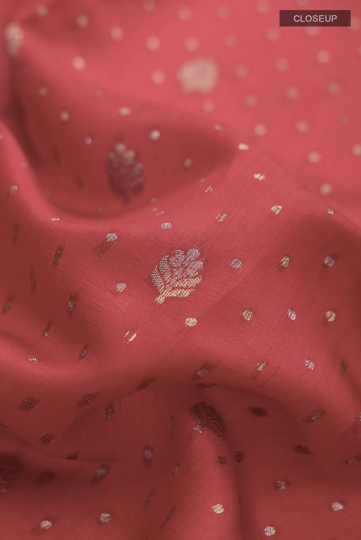 Close up of Red Raw Silk Saree with Zari Butta on the body and Zari Border displaying folds